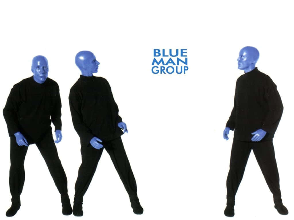 Blue Man Group 桌布 壁紙 — 三位藍面表演者身穿黑色服裝，在純白色背景前擺姿勢，背景上有'BLUE MAN GROUP'字樣。