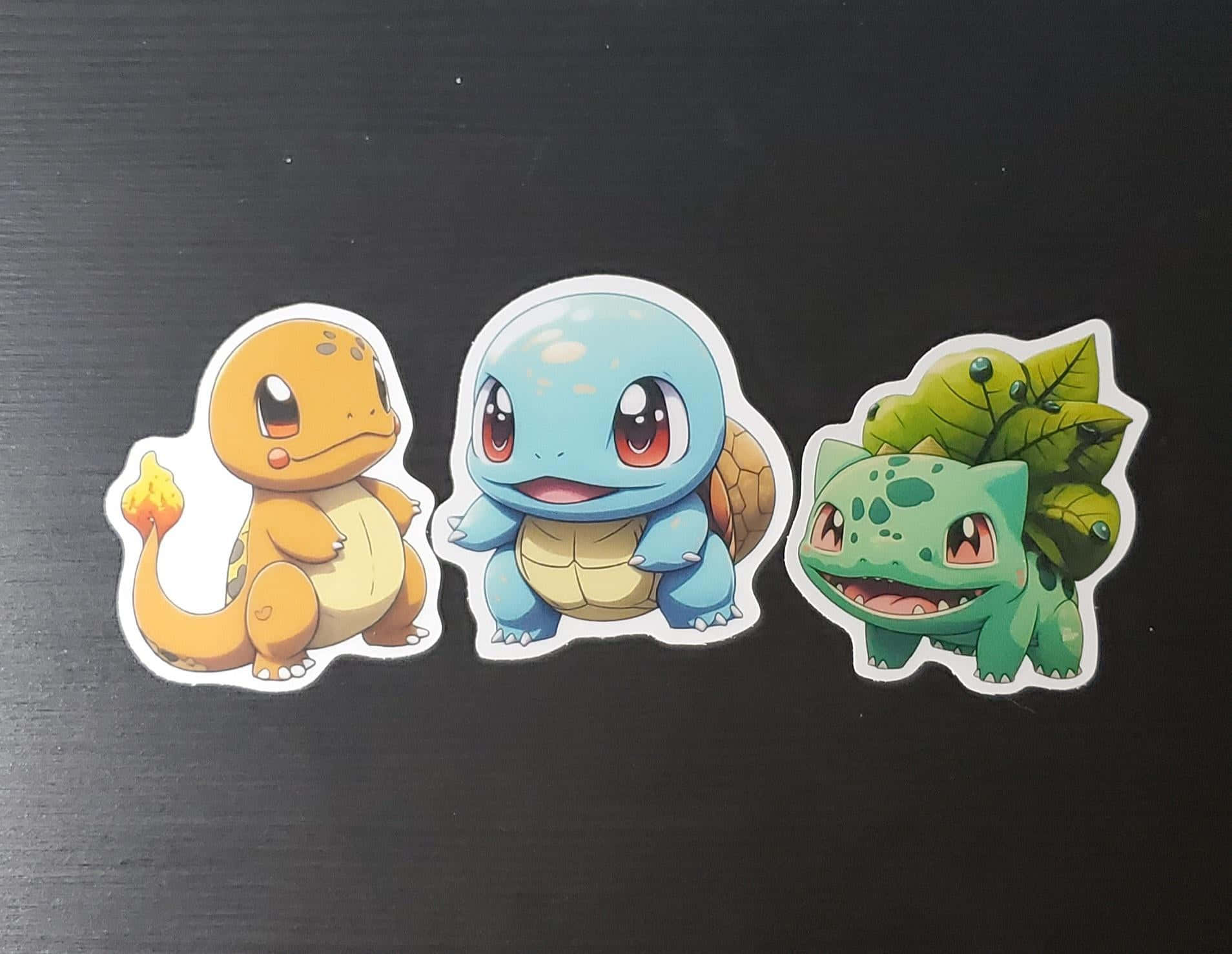 Pokemon Stickers 桌布 壁紙 — 三個可愛嘅寵物小精靈貼紙：小火龍、車厘龜同奇異種子，排列喺深色紋理表面上。