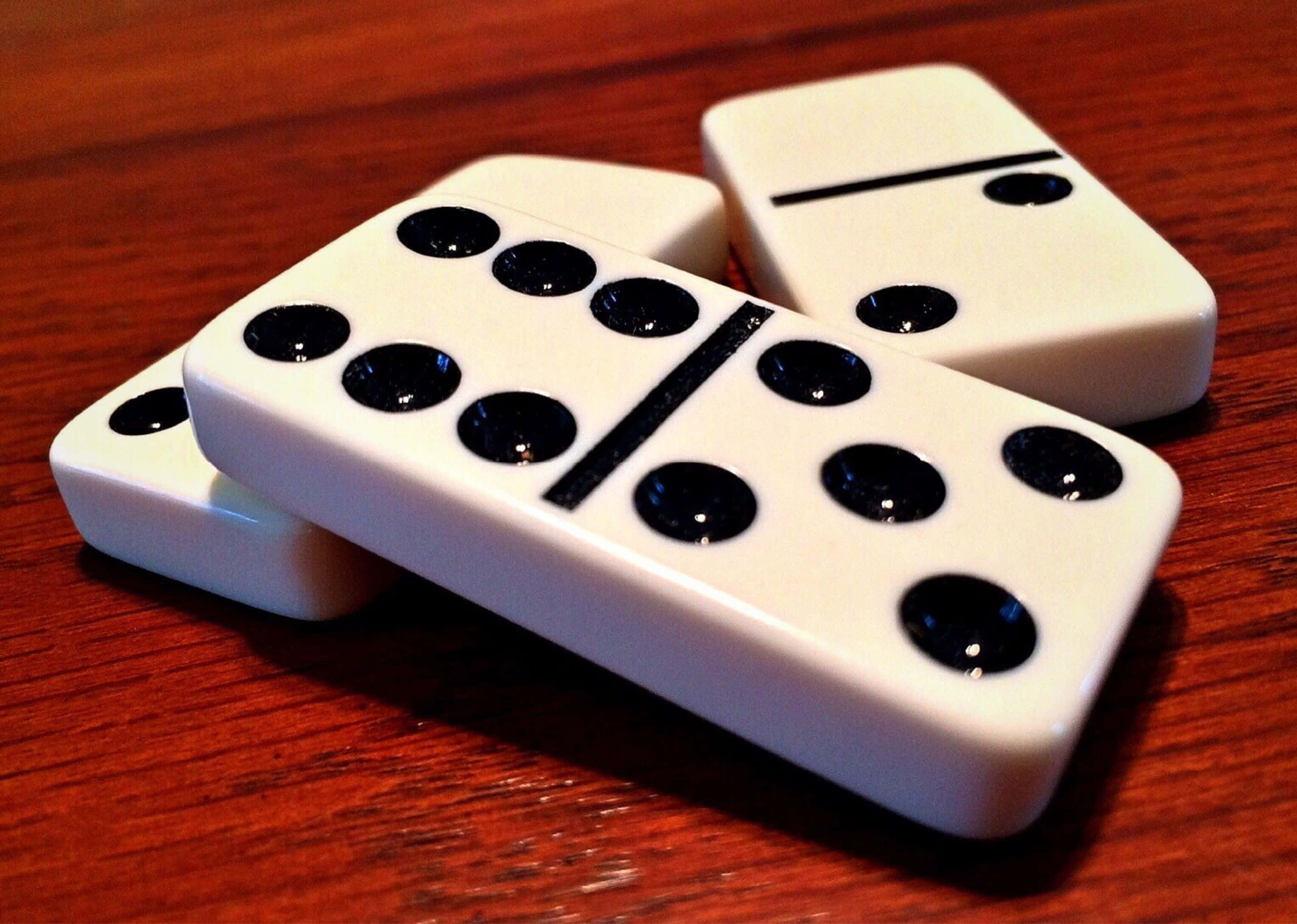 Domino 桌布 壁紙 — 三個帶有黑點的白色的多米諾骨牌放在溫暖的木桌面上。
