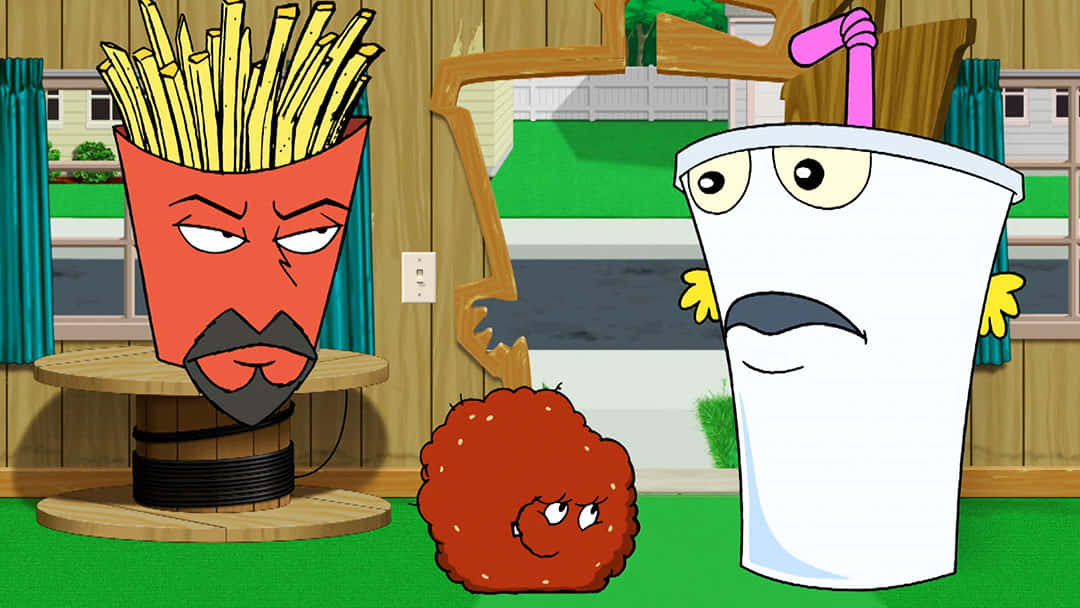 Adult Swim《Aqua Teen Hunger Force》 壁紙 — 三個擬人化的快餐物品，有臉孔，站在一個有木牆和綠色地板的卡通廚房裡。