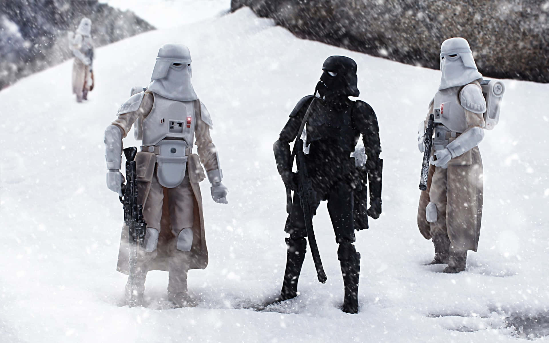 Imperial Army 桌布 壁紙 — 三個星戰雪地兵和一個黑色裝甲人物在雪山斜坡上的暴風雪中行進。