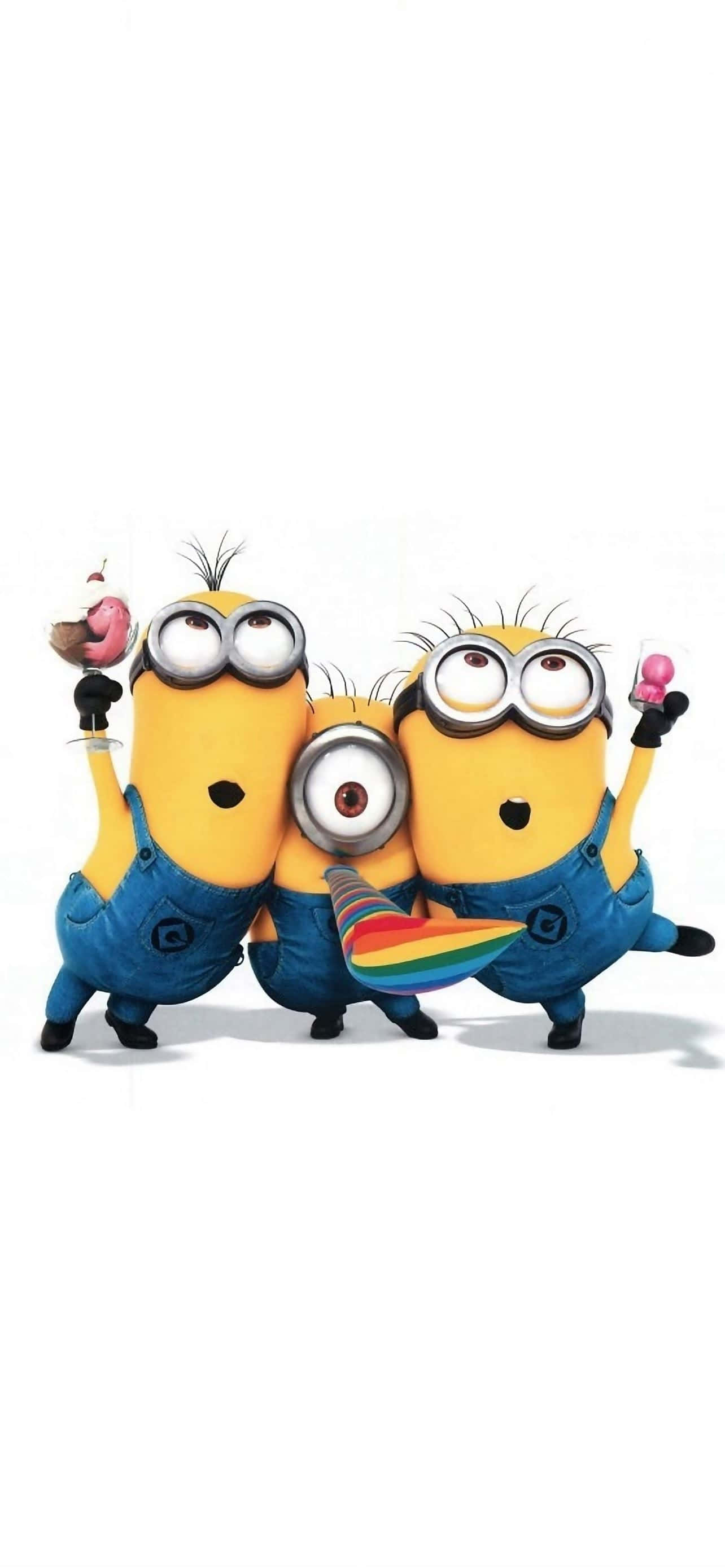 迷你兵團 桌布 壁紙 — 三個穿著藍色工裝褲的開心黃色Minions，戴著彩虹帽子和拿著糖果，在純白色背景前擺姿勢。