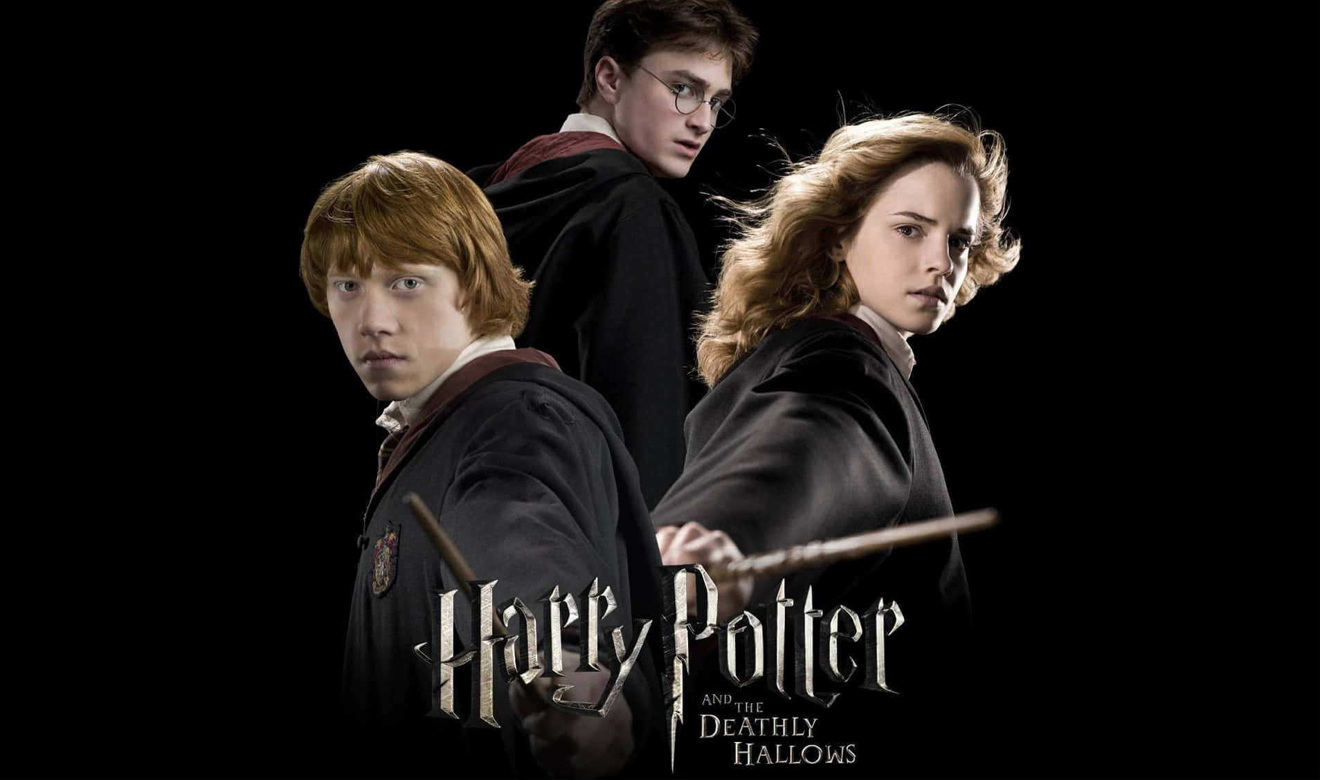 The Deathly Hallows 桌布 壁紙 — 三個穿著霍格華茲長袍的巫師，手持魔杖，站在純黑背景前，眼神專注而堅定。