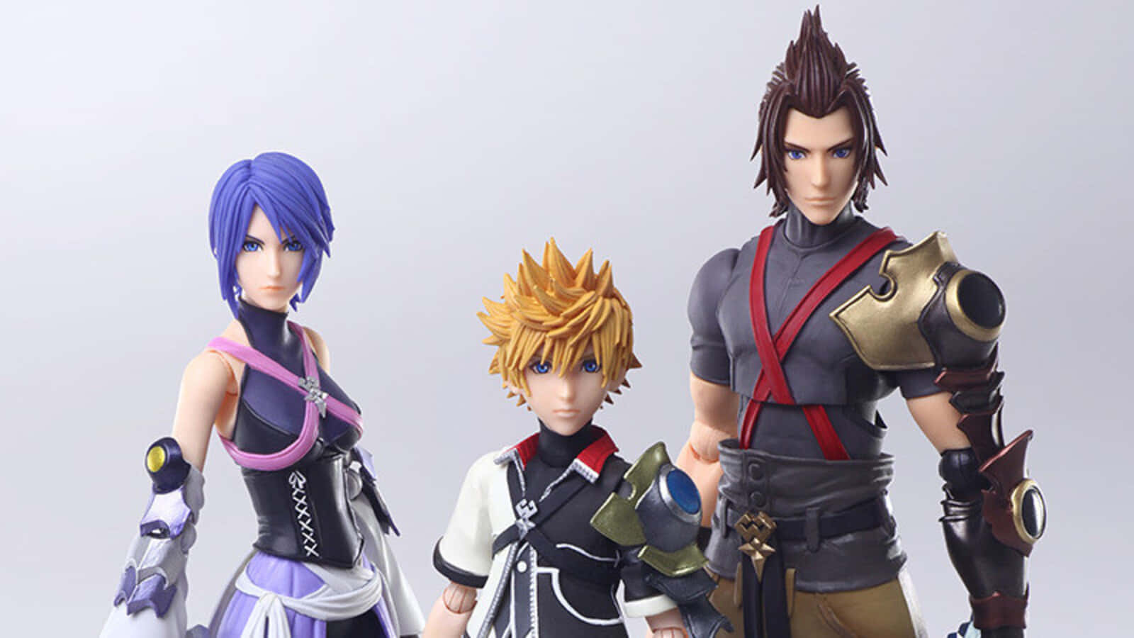 Kingdom Hearts Terra 桌布 壁紙 — 三個精細的王國之心可動人偶在純白背景前擺出姿勢，展示鮮豔的服裝和複雜的盔甲設計。