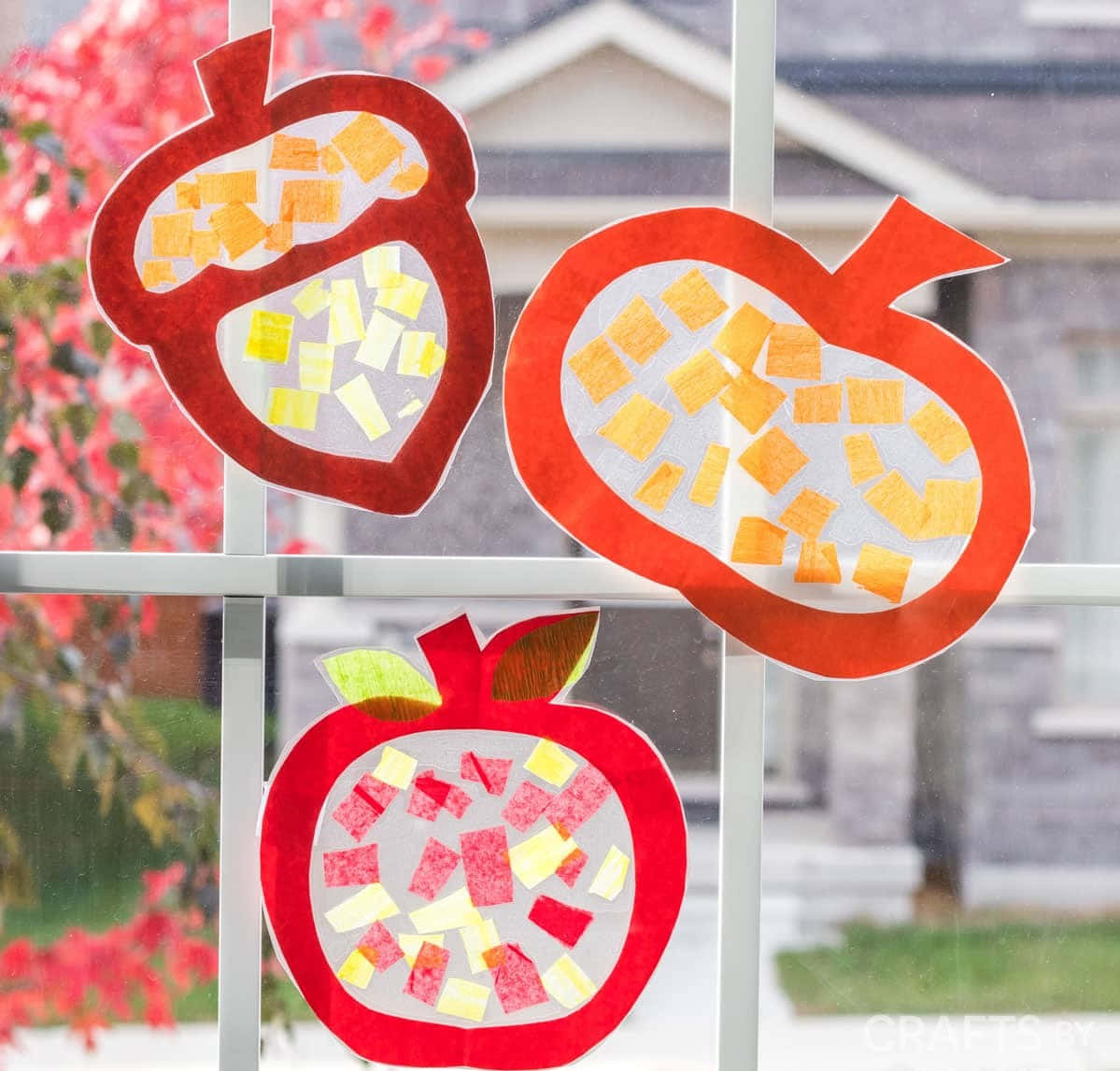 Fall Crafts 桌布 壁紙 — 三個紅色紙製水果剪紙，內有彩色便利貼，掛在窗上，窗外可見秋葉。