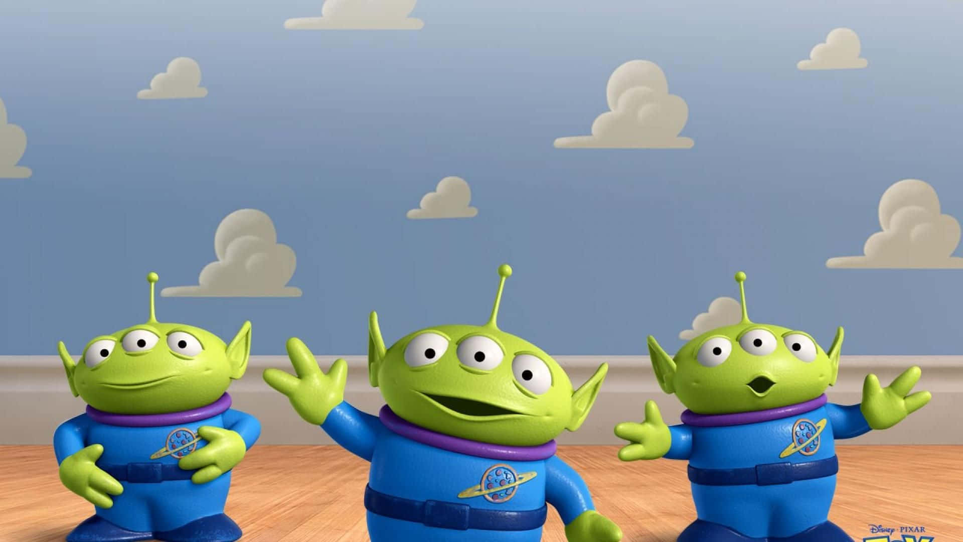 Toy Story Cloud 桌布 壁紙 — 三個綠色三眼外星人穿著藍色太空衣，在風格化的天空和蓬鬆雲朵前愉快地揮手。