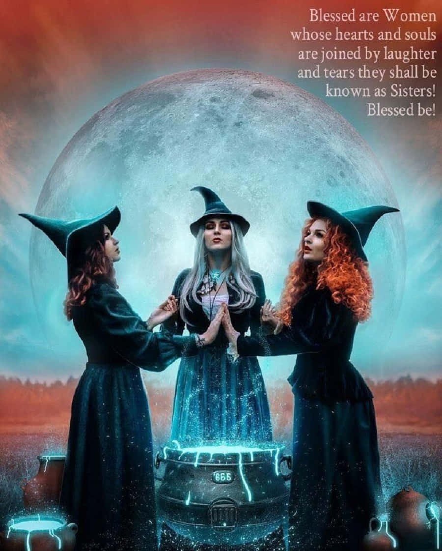 Witch Costumes 桌布 壁紙 — 三個身穿深色長袍、頭戴尖帽的女巫，站在一個巨大的月亮下，圍著一個發光的大鍋，月亮投射出詭異的藍色和橙色光芒。