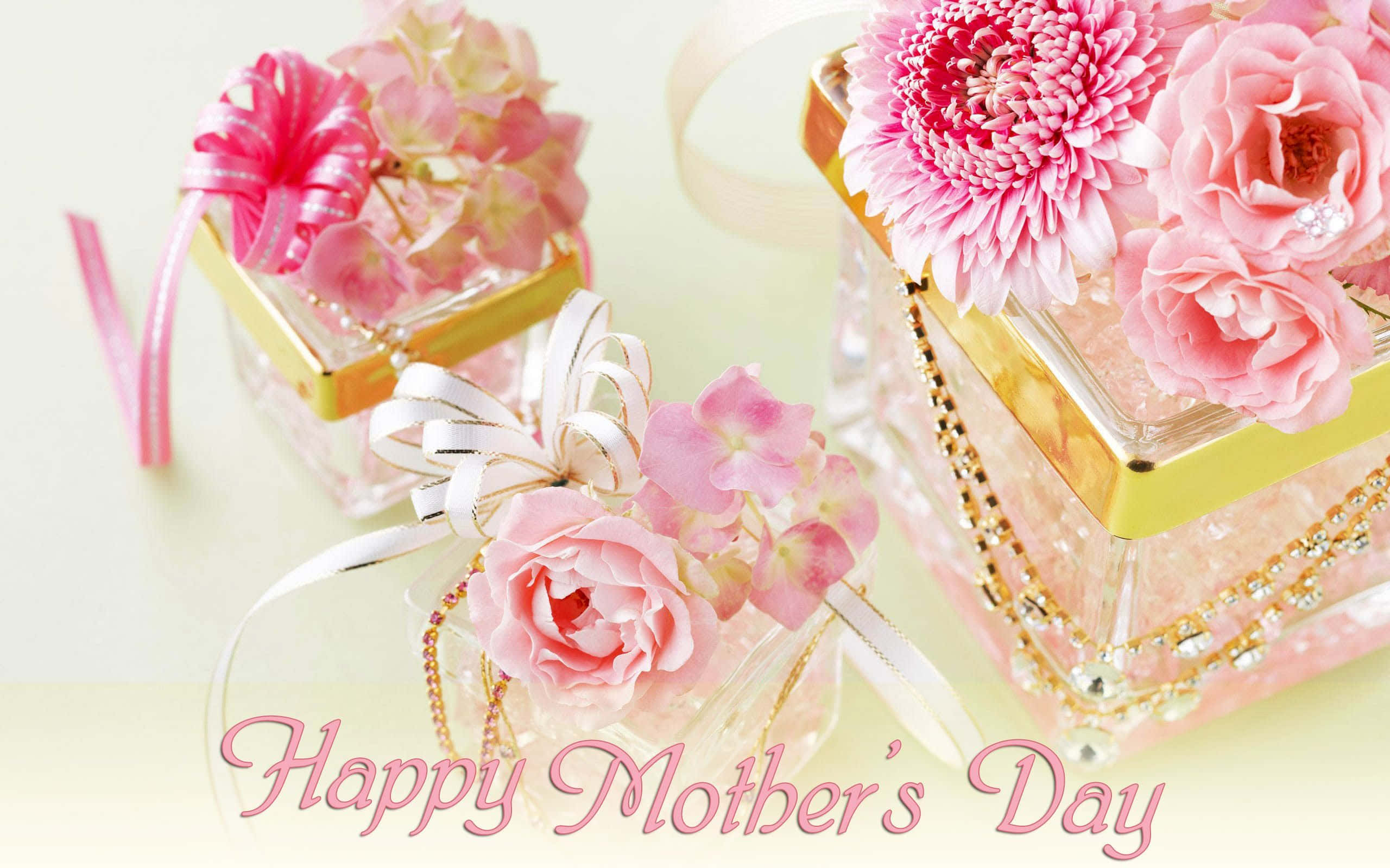 Happy Mothers Day 桌布 壁紙 — 三個金邊玻璃盒裝有粉紅色花朵和絲帶，慶祝母親節。
