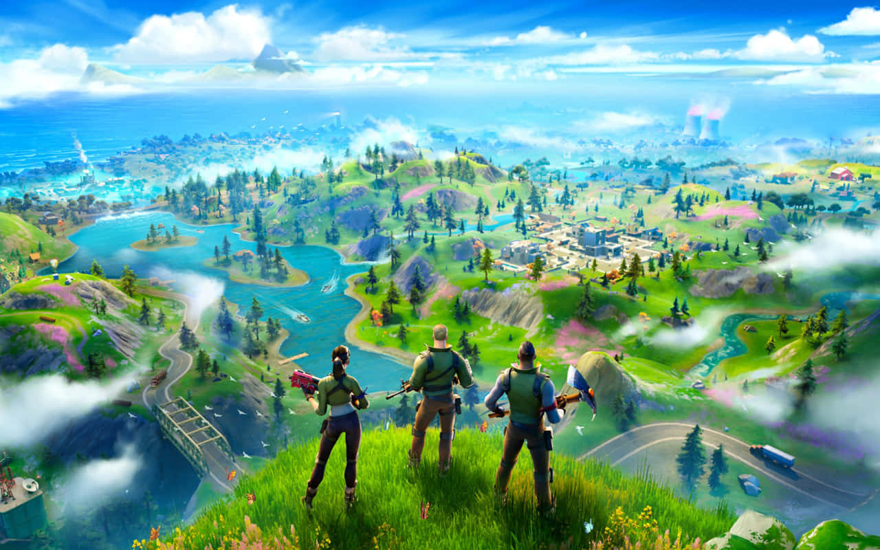 要塞英雄 大逃殺 桌布 壁紙 — 三名 Fortnite 玩家站在長滿青草的懸崖頂上，俯瞰著一個充滿活力的島嶼，島上有湖泊、森林和遠處的城鎮，天空湛藍。