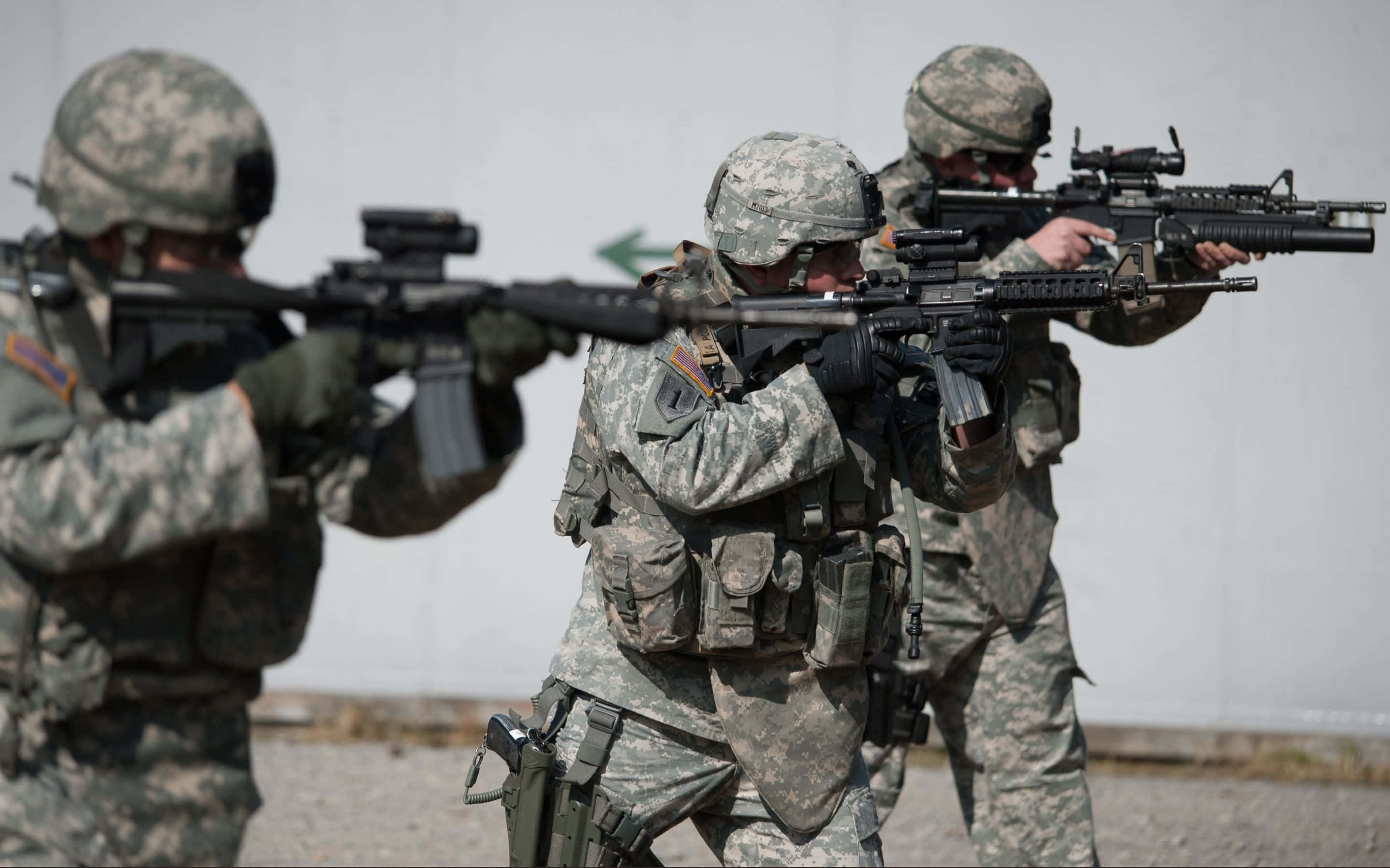 Army 桌布 壁紙 — 三名身穿迷彩裝備的士兵在專注的訓練演習中，對準一面素牆瞄準步槍。