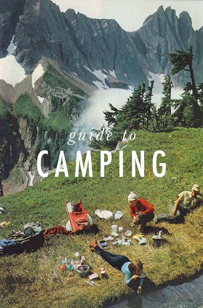 Winter Camping 桌布 壁紙 — 三名露營者喺草地山坡上放鬆，背景係白雪覆蓋嘅山峰同松樹。