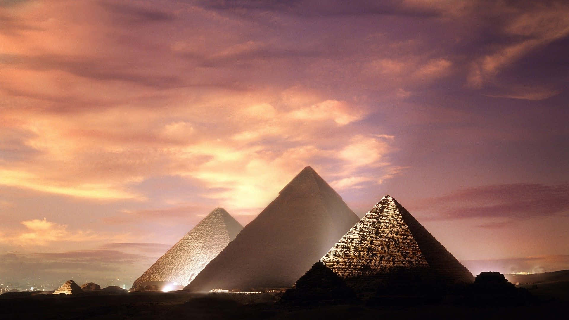 Egypt 桌布 壁紙 — 三座古老金字塔在橙紫雲彩的絢麗日落天空下呈現剪影。