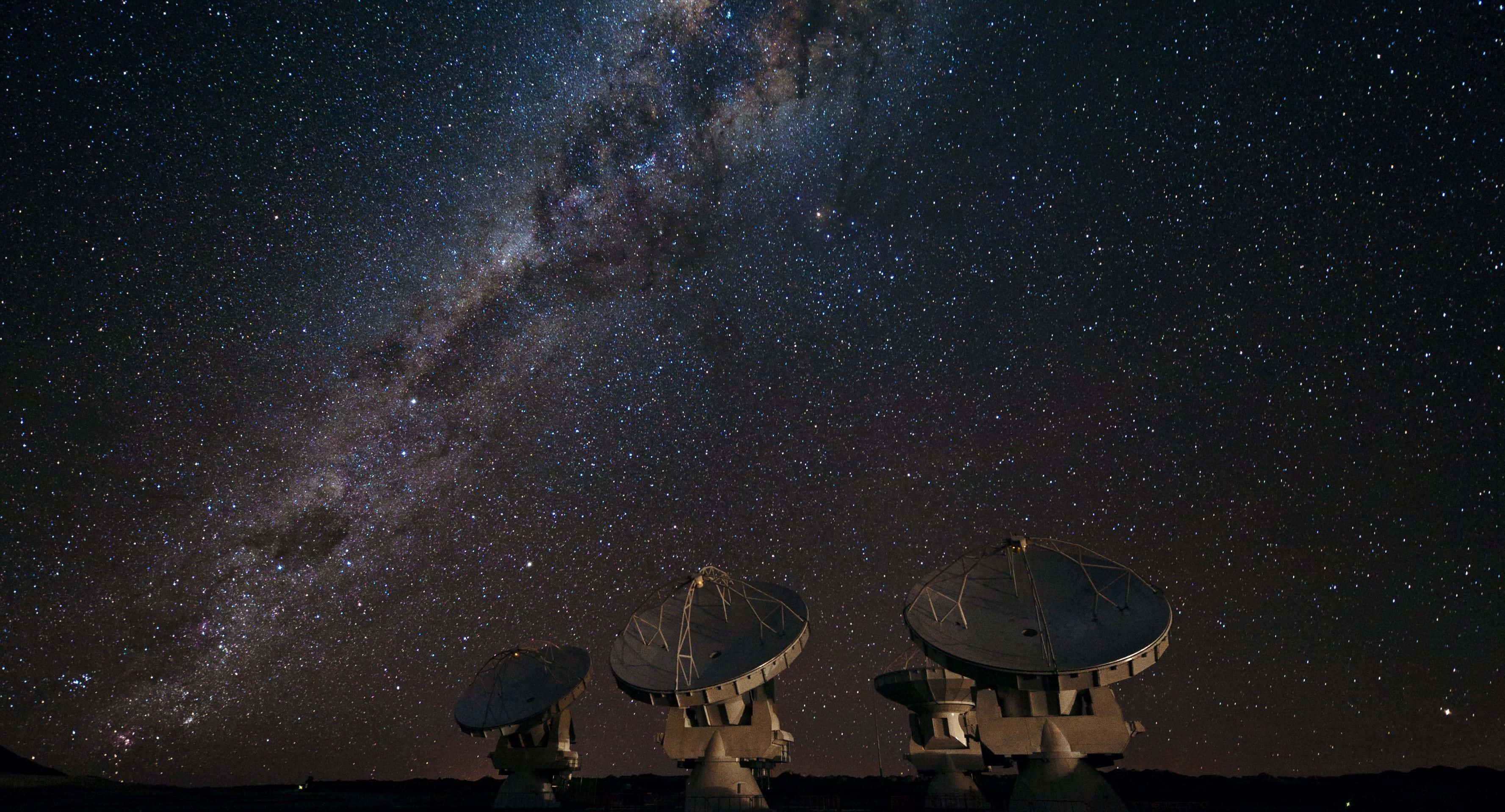 Satellite 桌布 壁紙 — 三座無線電望遠鏡在壯麗的星空夜空下呈現剪影，銀河在頭頂閃耀。