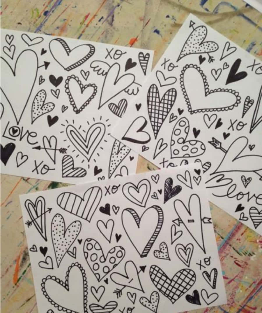 三張紙上畫有塗鴉心形和「love」文字，背景是顏料濺灑的效果。 — 粉紅色心形動圖 壁紙