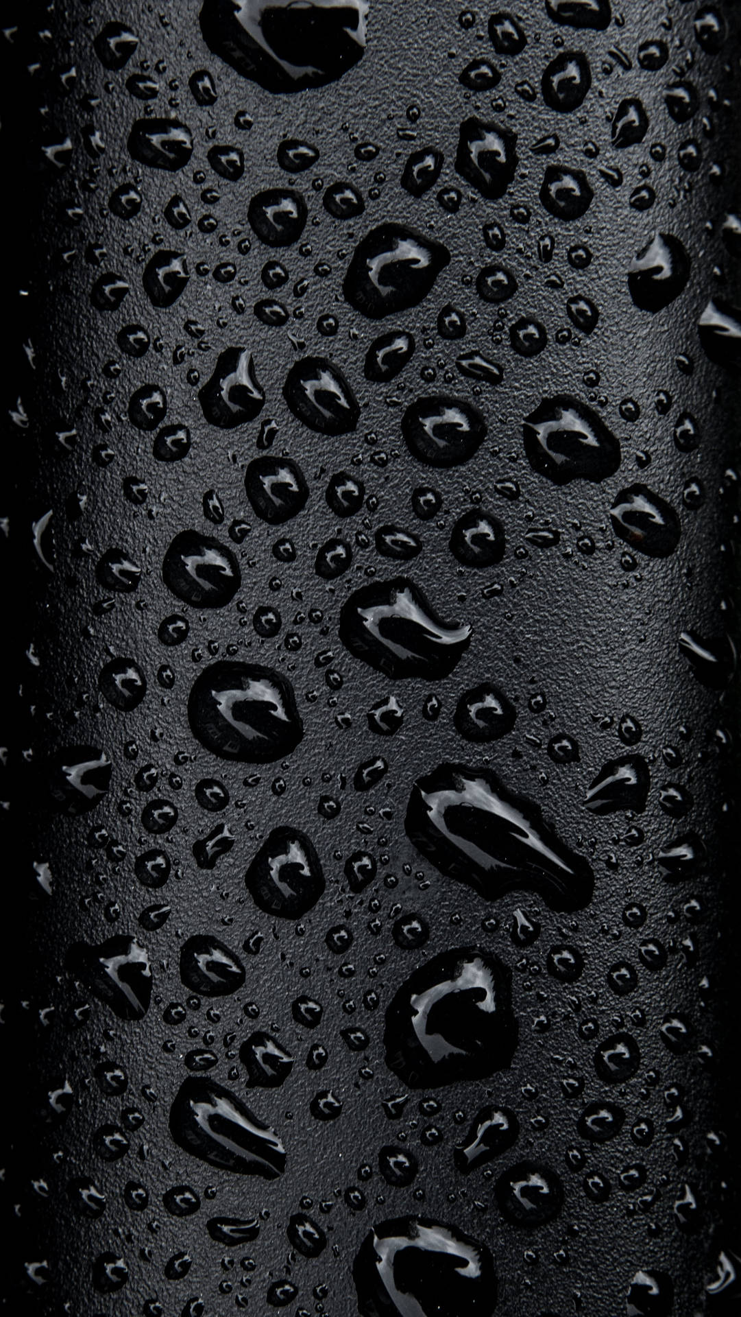 黑色紋理表面上的雨滴特寫