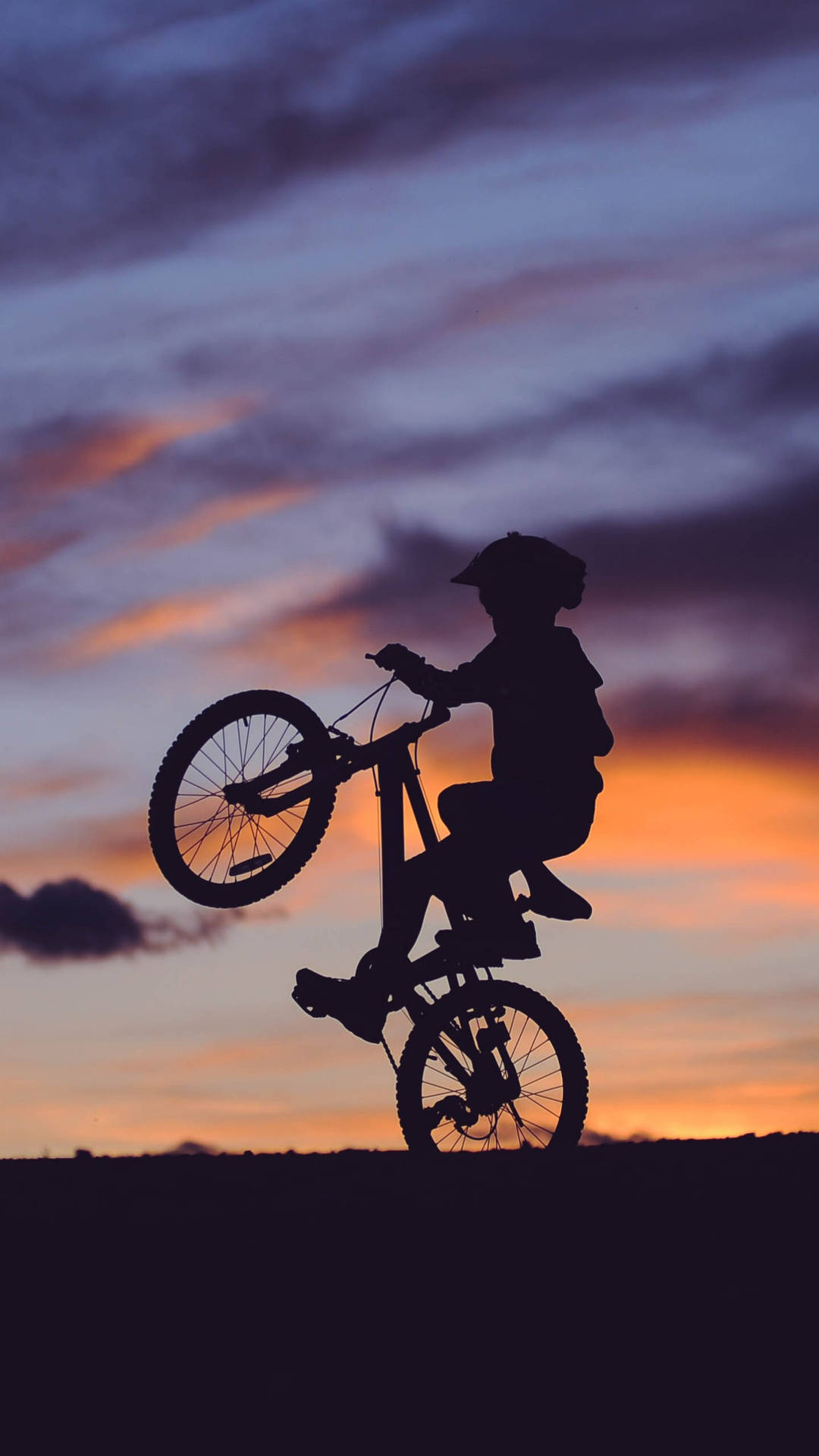 孩子在日落時騎單輪單車