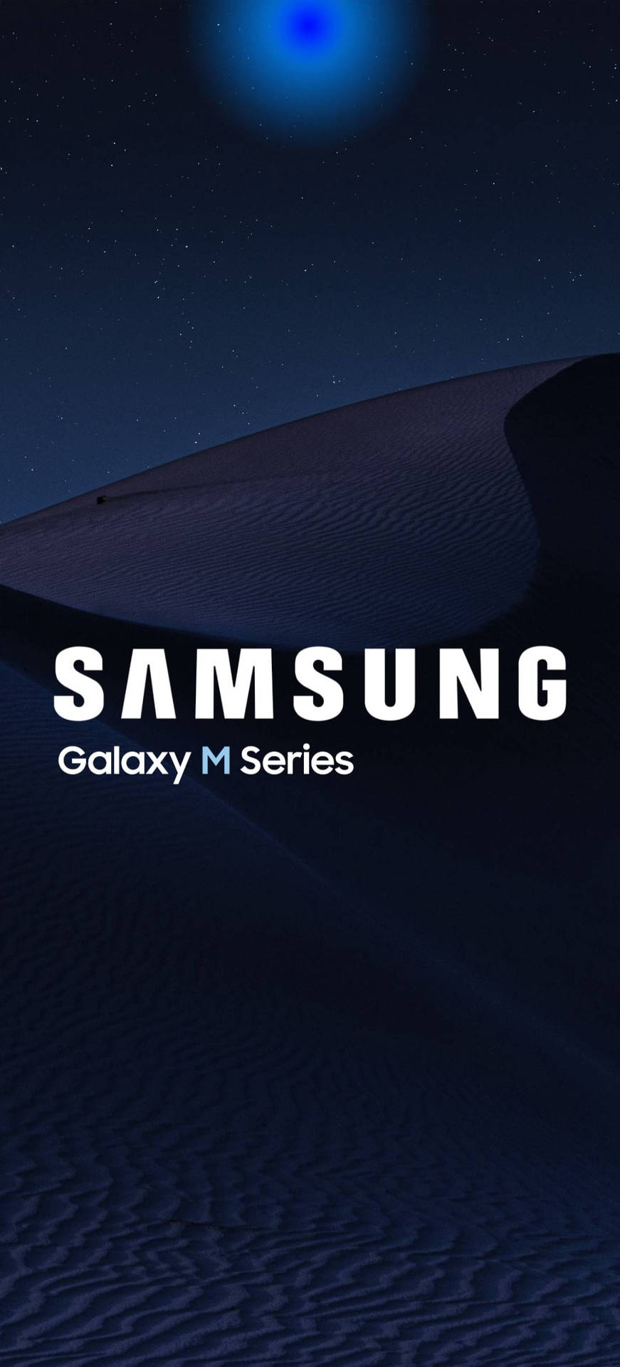 星空下黑暗沙漠沙丘，發光藍色球體，Samsung Galaxy M系列文字。