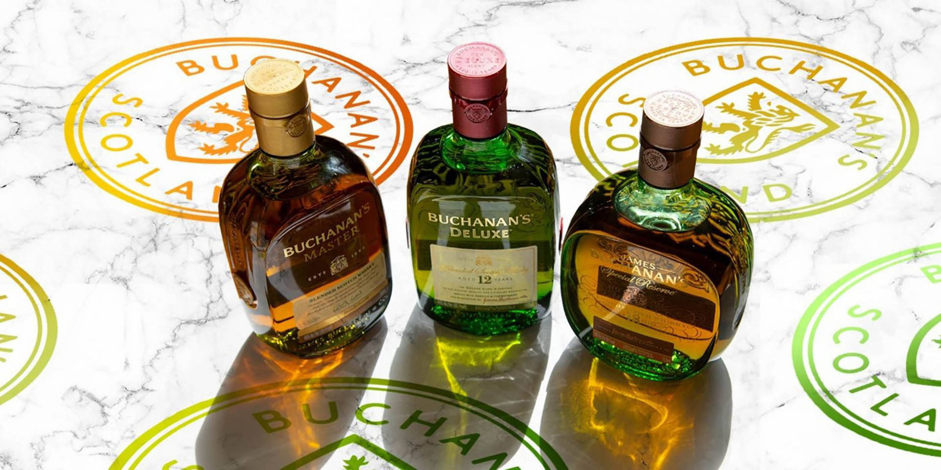 三瓶 Buchanan's 威士忌在品牌大理石背景上。