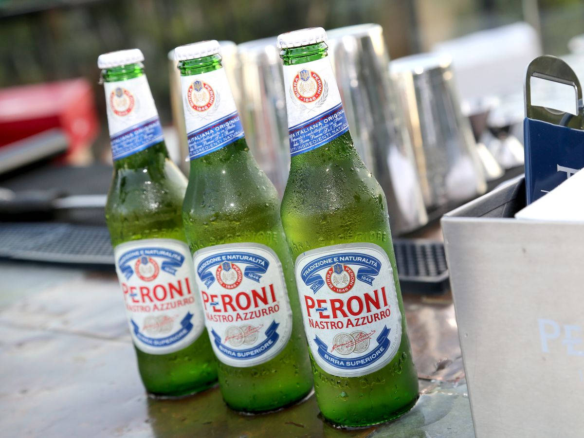 三瓶冰凍的Peroni啤酒在金屬桌上凝結水珠。