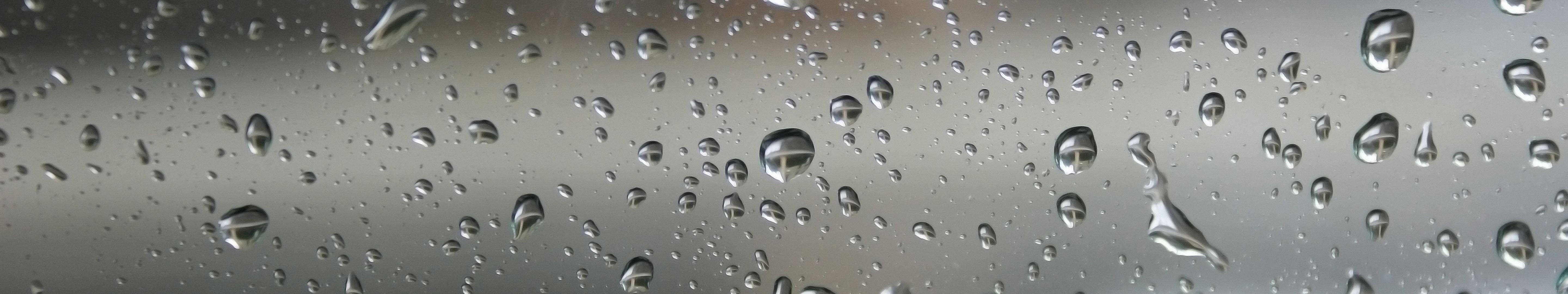 玻璃上的雨滴反射灰色天空