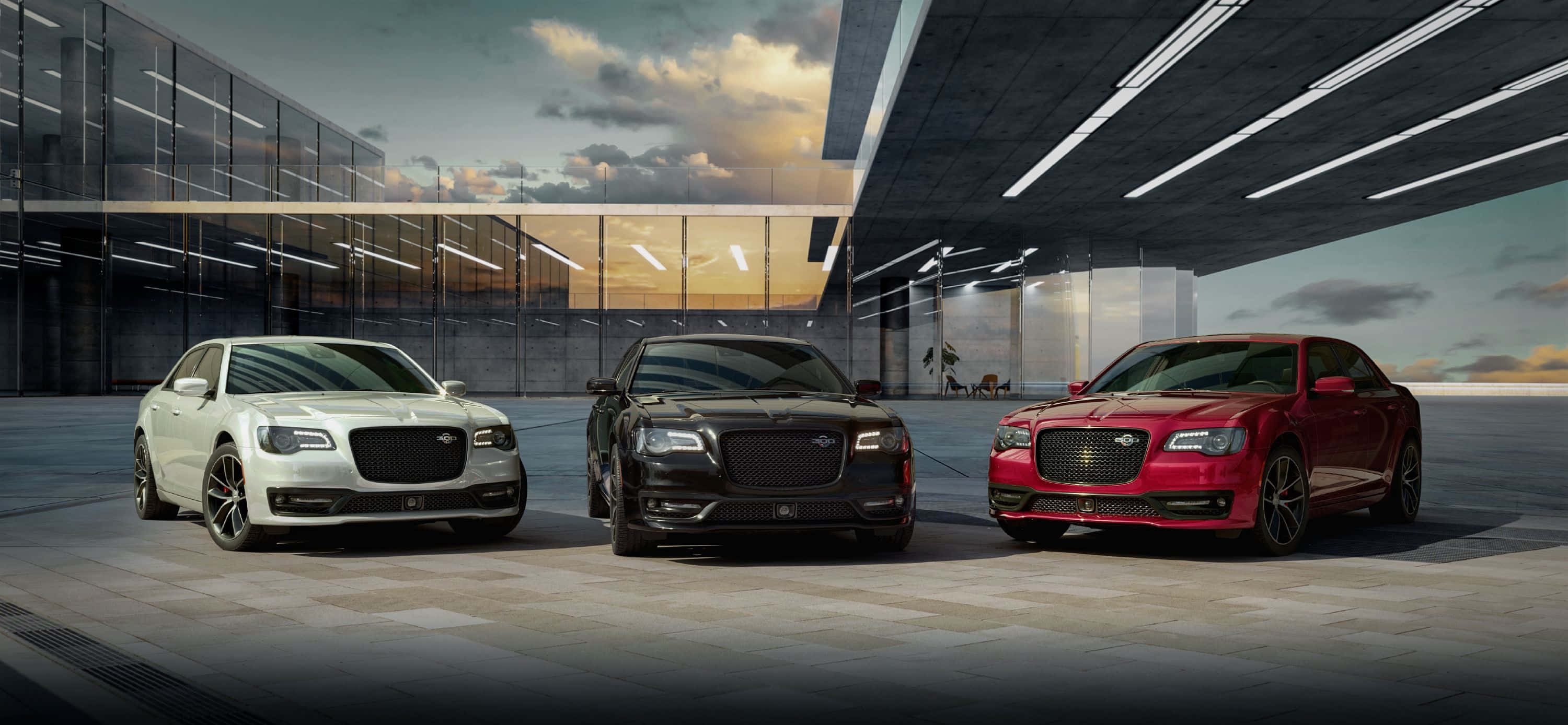 Chrysler 300 桌布 壁紙 — 三輛白色、黑色和紅色的豪華轎車在黃昏時分停放在現代玻璃和鋼製簷篷下。