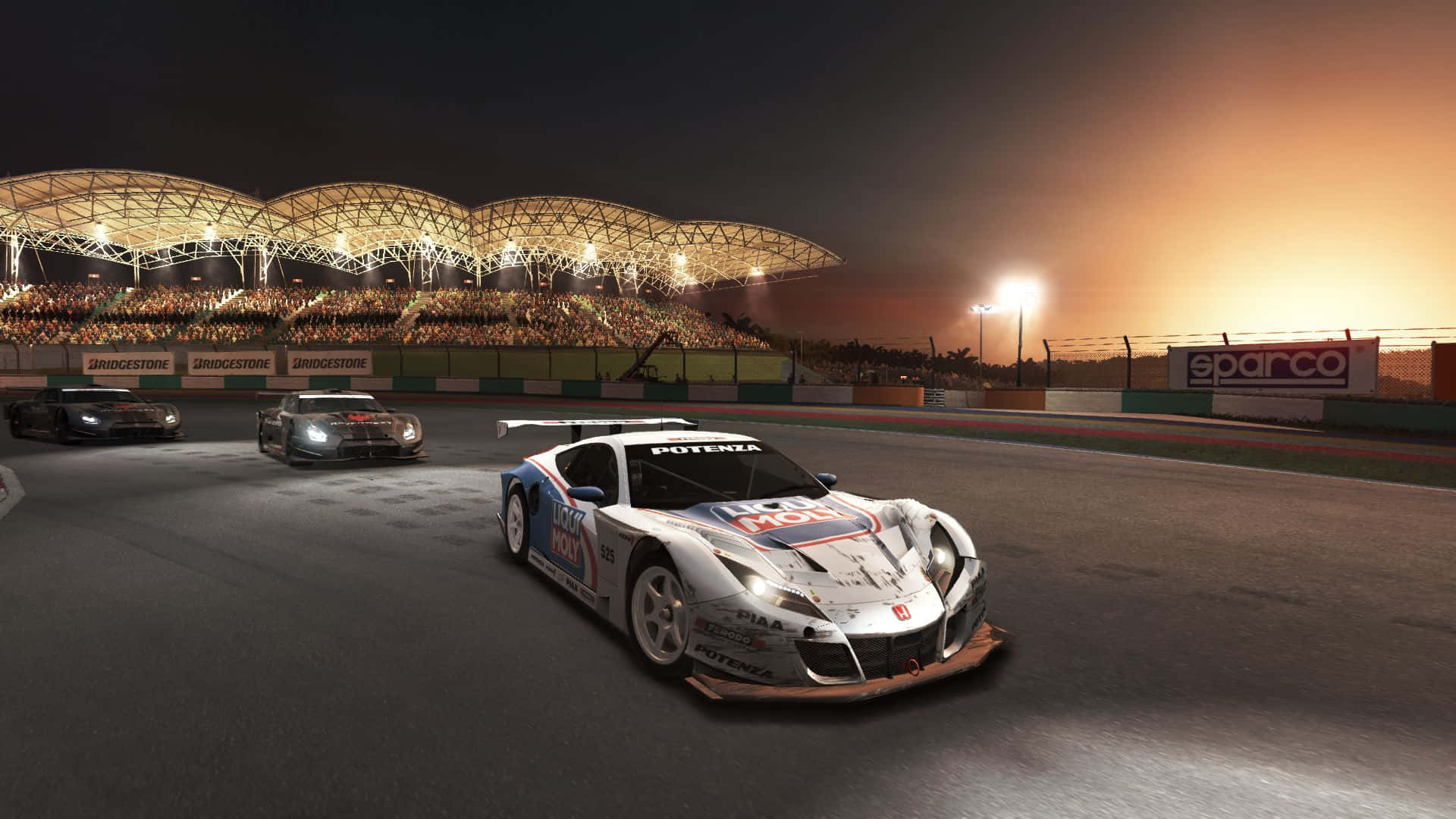 Grid Autosport 桌布 壁紙 — 三輛賽車在黃昏時分，於燈火通明的體育館和座無虛席的看台下，在賽道上飛馳。