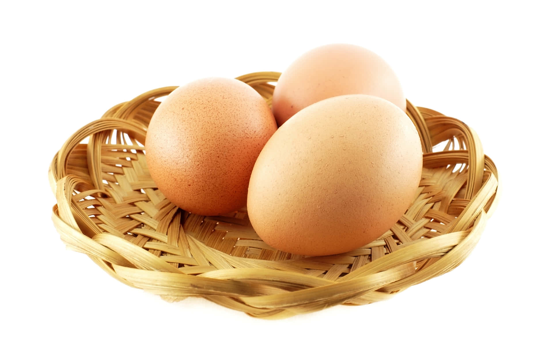 Eggs 桌布 壁紙 — 三隻光滑的棕色雞蛋放在一個編織竹籃裡，背景是潔淨的白色。