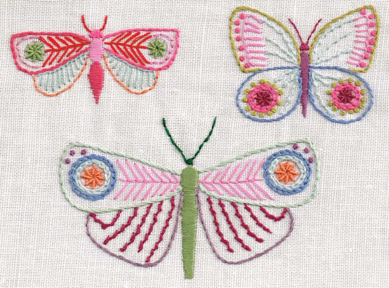 三隻刺繡蝴蝶，布料上有色彩繽紛的圖案。 — 唯美蝴蝶動圖 壁紙