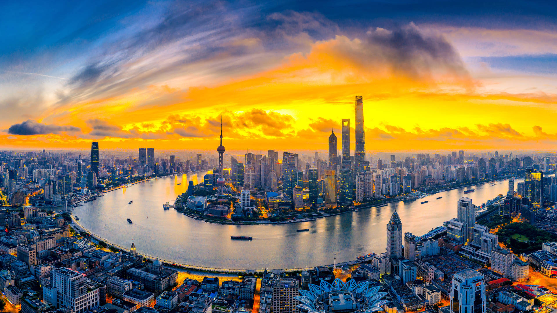 上海城市全景 壁紙 — 上海天際線的鳥瞰圖，夕陽西下，金色雲彩映照在黃浦江上。