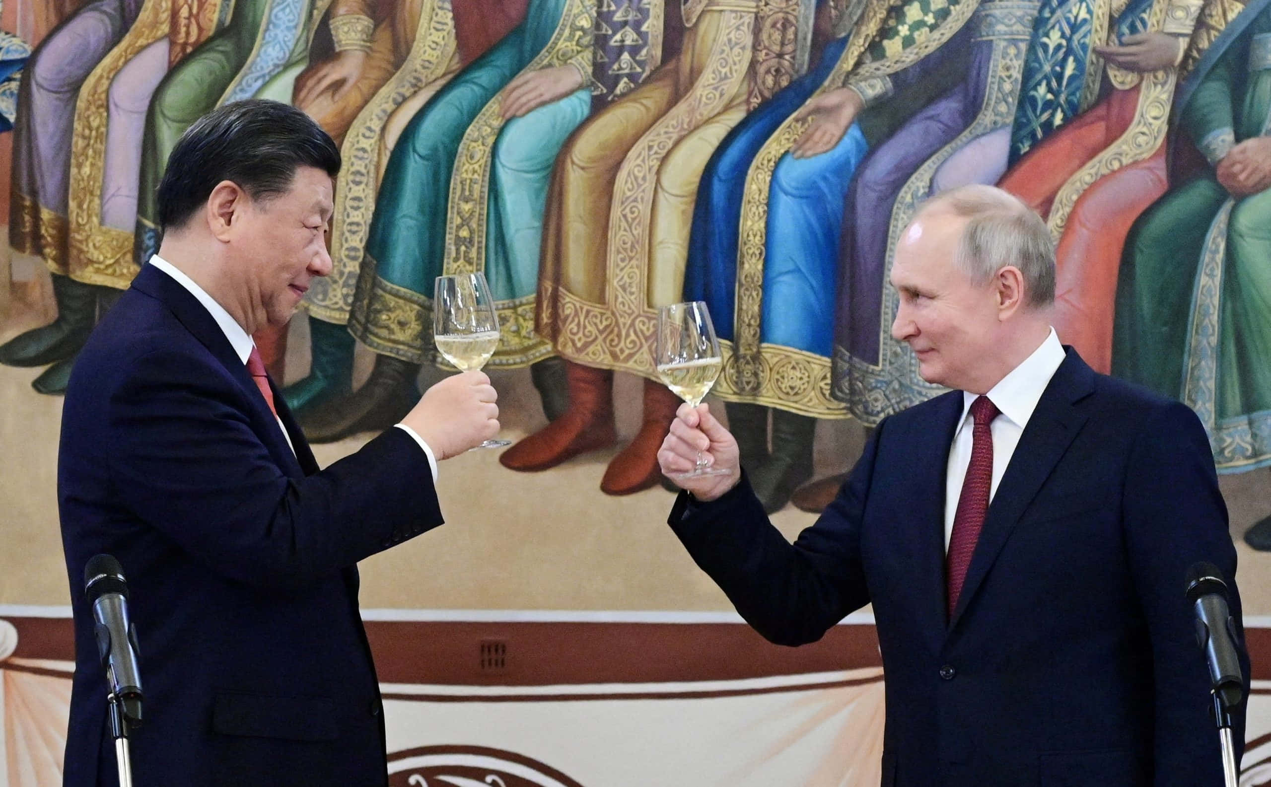 上海璀璨的黃金天際線 壁紙 — 兩位身穿深色西裝的世界領袖在色彩繽紛的歷史壁畫前碰杯。