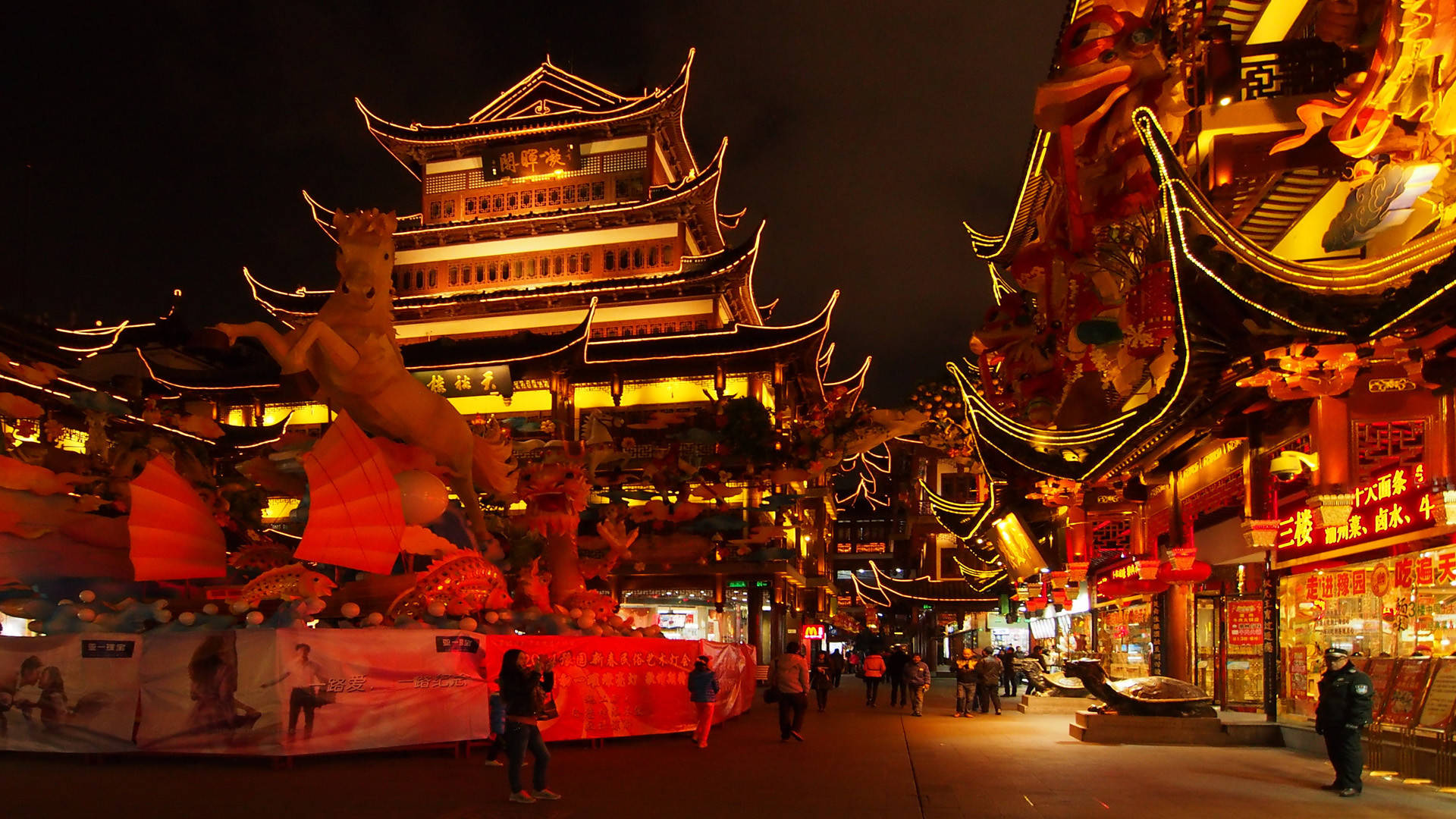 上海豫園夜景 壁紙 — 傳統中國街道的充滿活力的夜景，有燈火通明的寶塔式建築和節日裝飾。