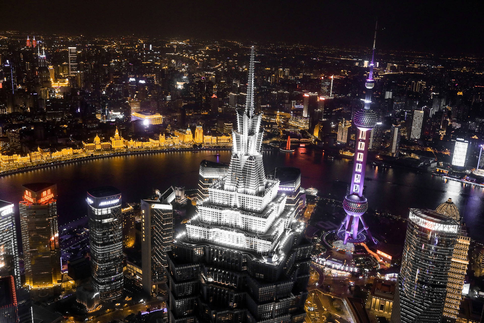 上海金茂大廈 壁紙 — 上海璀璨天際線的空中夜景，東方明珠塔和上海中心大廈在黃浦江上閃耀。