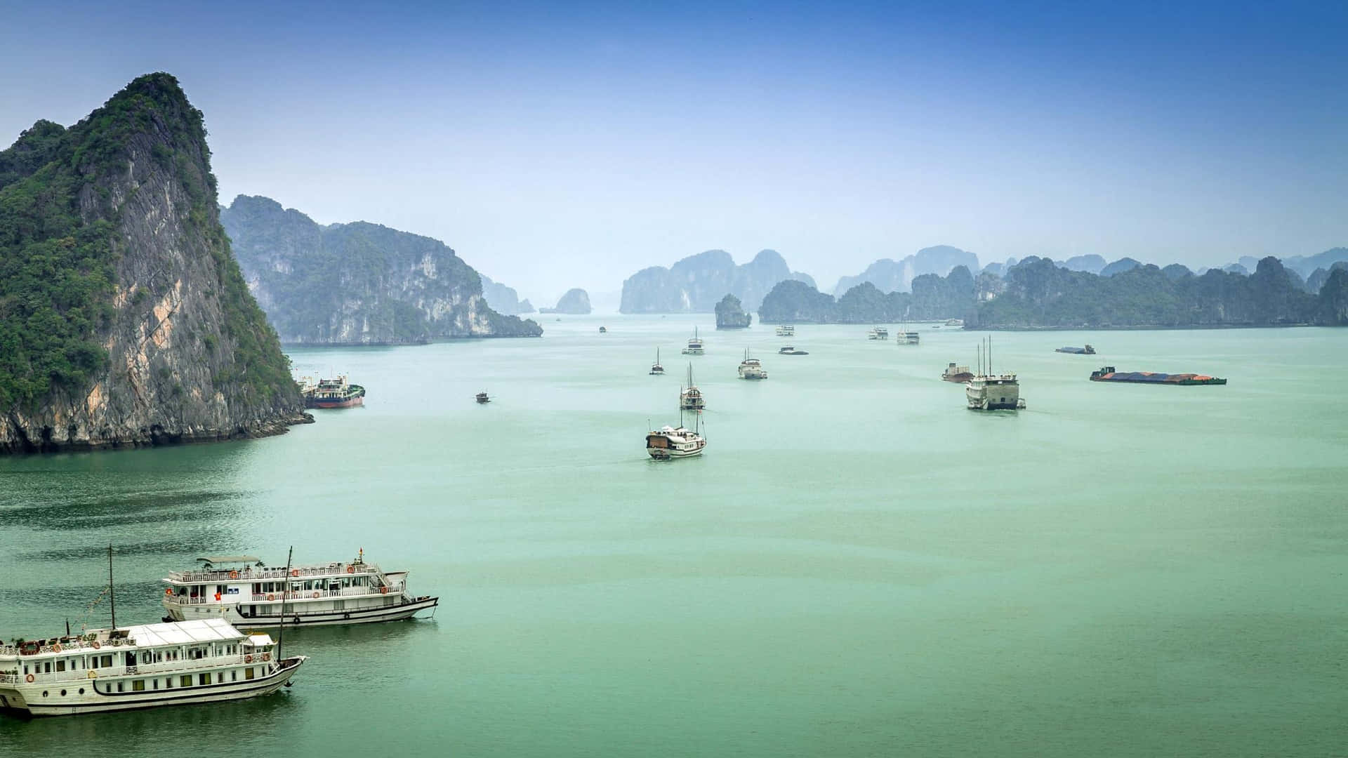 碧綠海灣，石灰岩喀斯特地貌和船隻，在清澈的藍天下