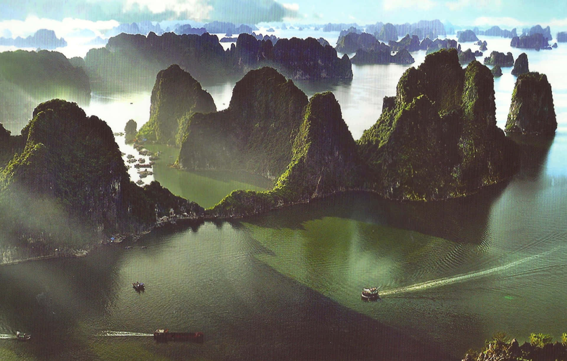 喀斯特島嶼從翡翠色海水中升起，船隻在霧氣瀰漫的航道中滑行。