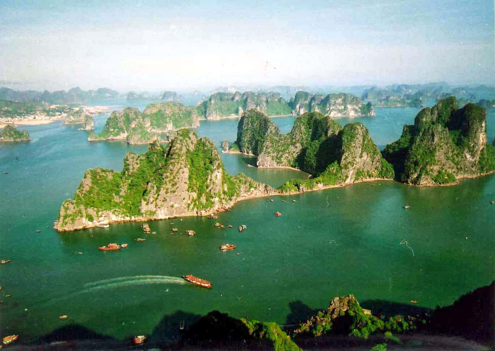 喀斯特島嶼從翠綠海水中升起，船隻在其間漂流。