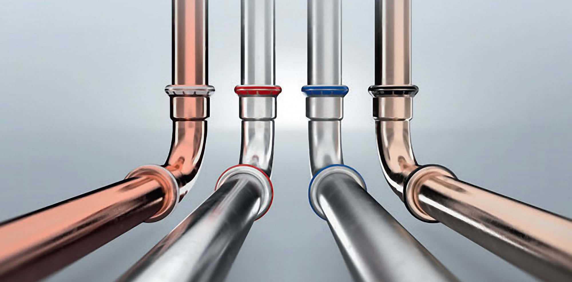 不同管路與 Plumbing 材料 壁紙 — 四條金屬管帶有銅和鉻飾面，在柔和的灰色背景下向觀眾匯聚。