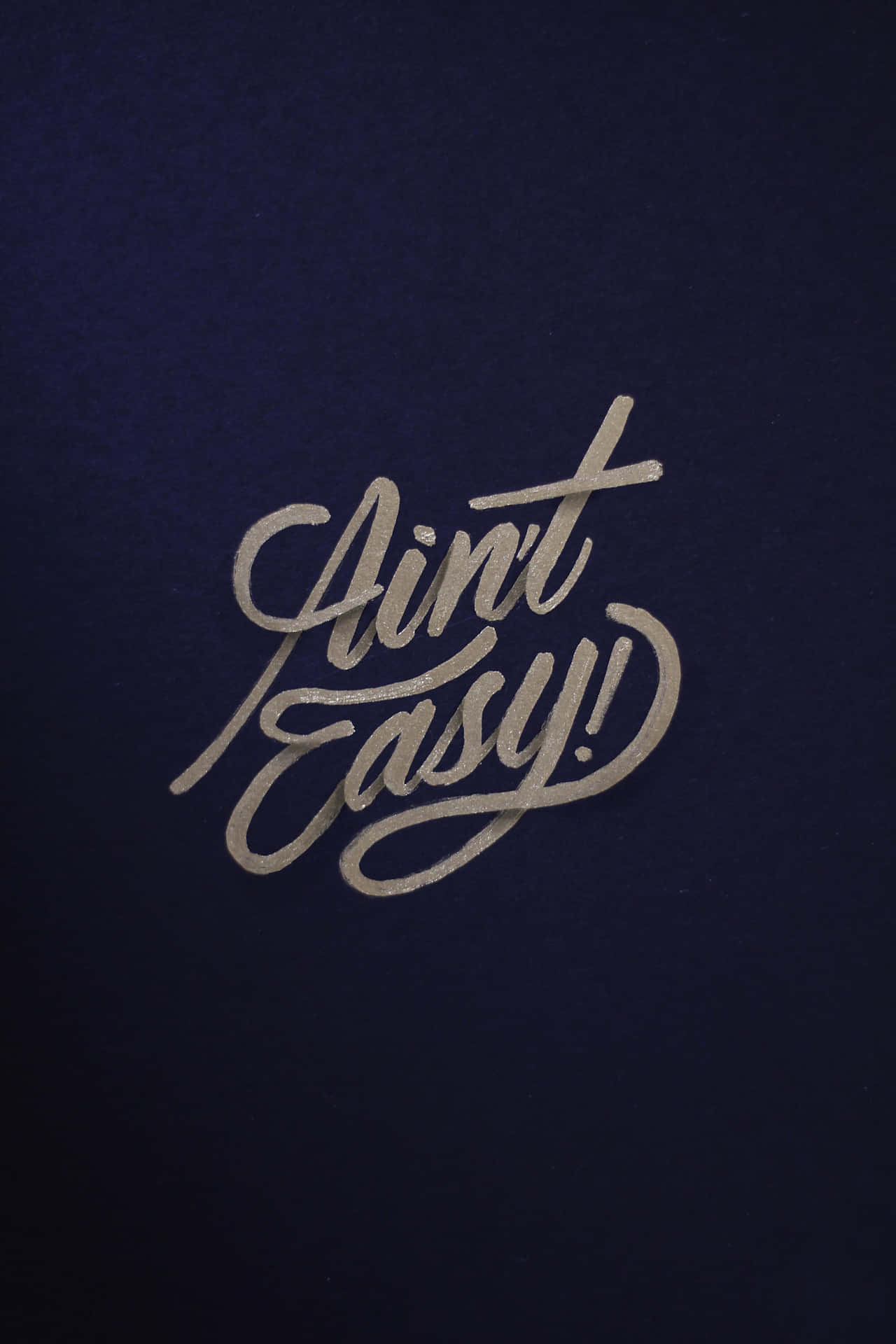 在海軍藍背景上顯示「Ain't Easy!」的銀色書法文字。