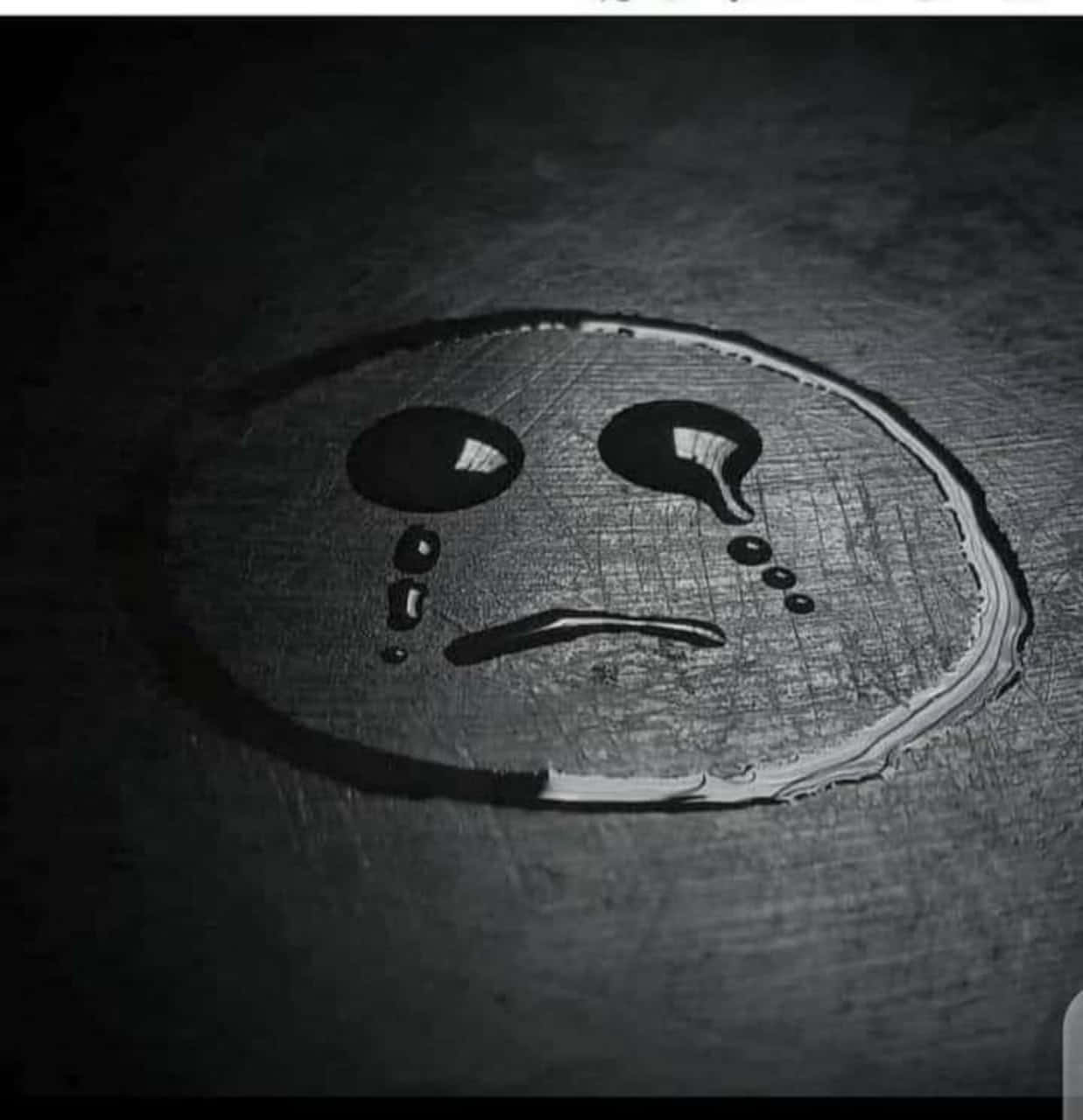不必強裝沒事，你也可以不OK。 壁紙 — 在戲劇性燈光下，由水滴在深色紋理表面上形成的悲傷面孔。