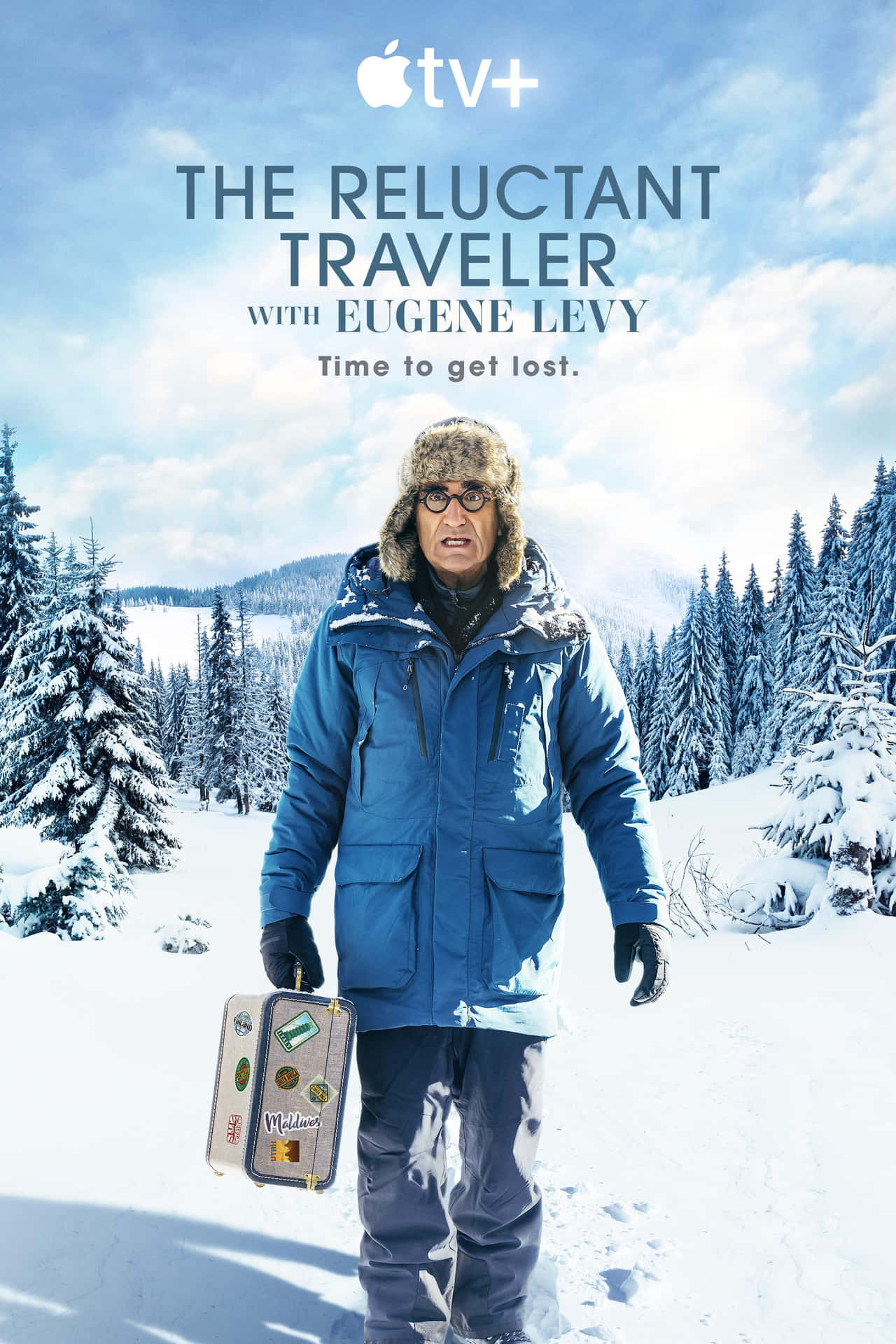 冬季裝扮的男人在雪地松林中手持手提箱。