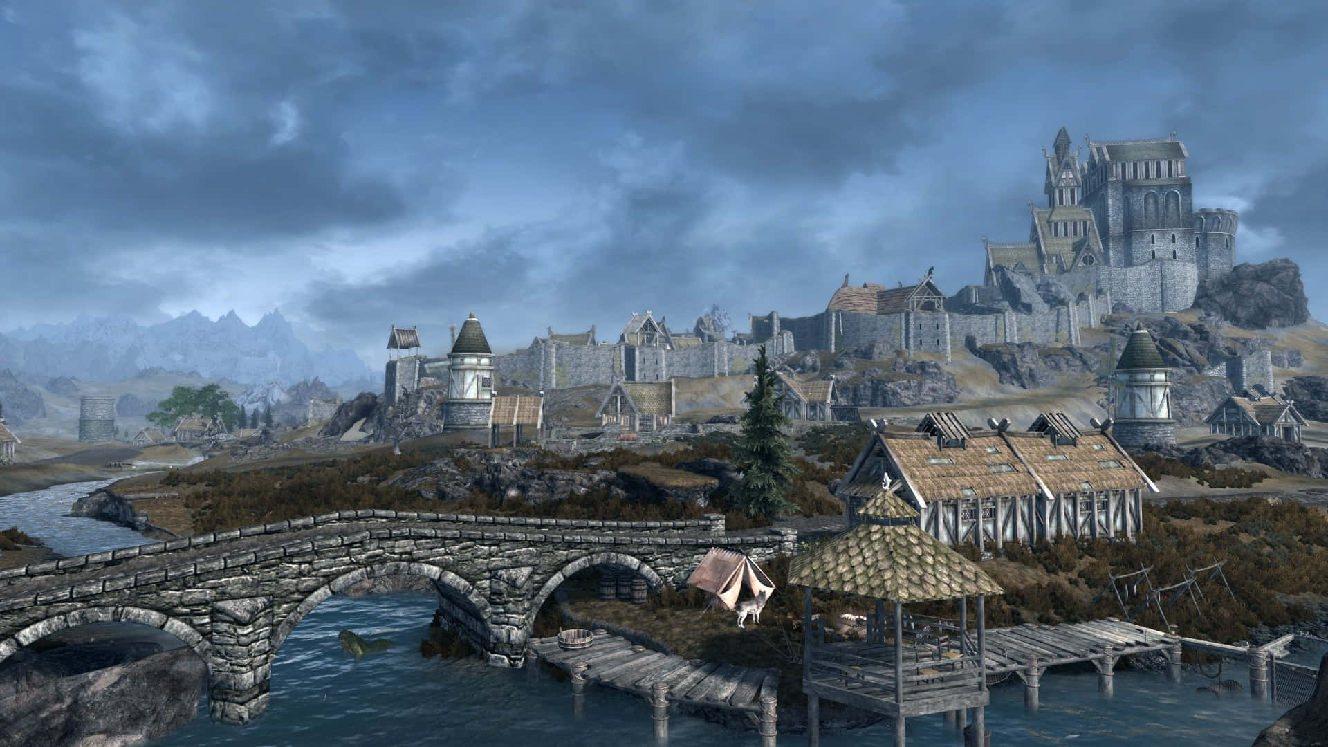 Skyrim Whiterun 桌布 壁紙 — 中世紀奇幻村莊，石橋與城堡矗立於懸崖上，天空風暴來襲。