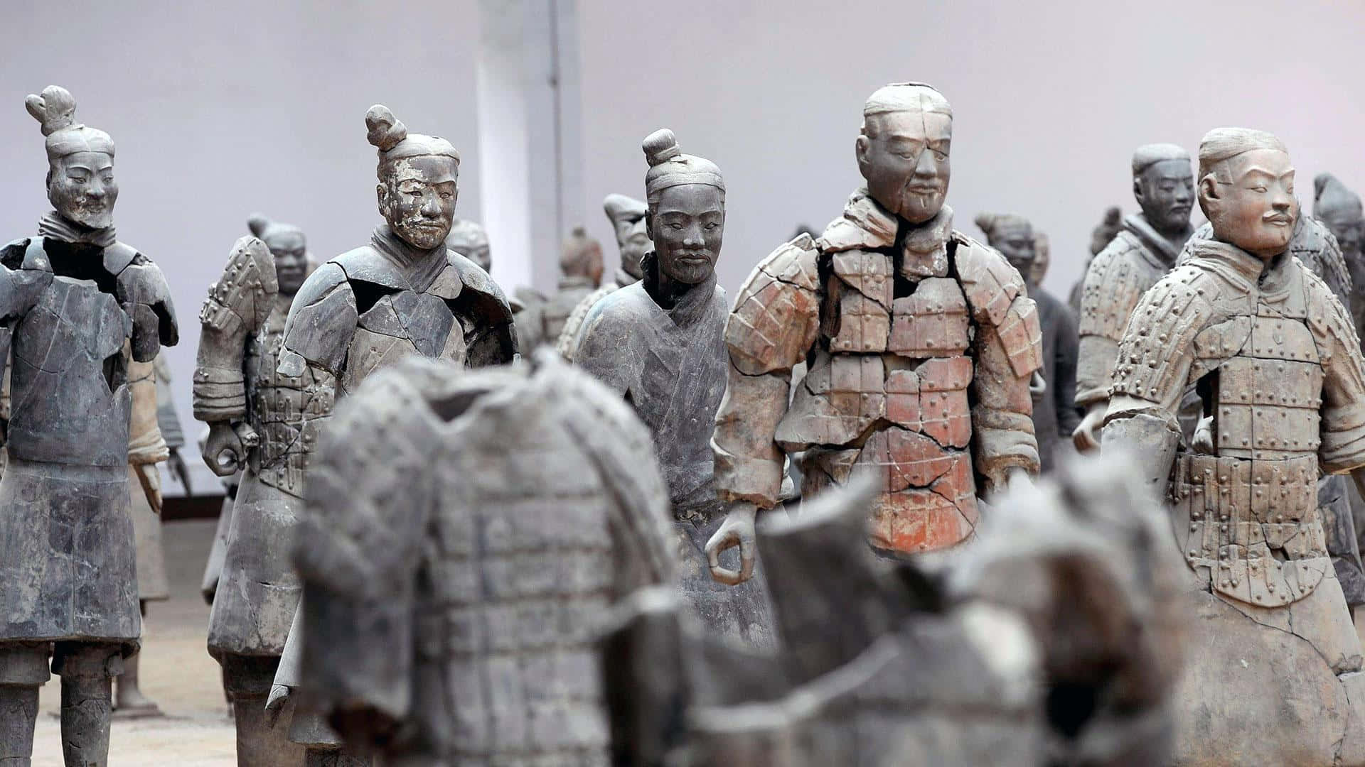 中國博物館內的兵馬俑軍隊葬禮藝術 壁紙 — 一排排古老的兵馬俑在博物館環境中整齊排列，帶有精細的盔甲和風化的表情。