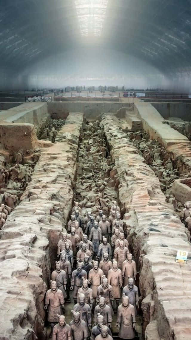 中國博物館陶俑雕塑酷照 壁紙 — 一排排古老的兵馬俑在保護玻璃屋頂下的考古發掘現場內列隊站立。