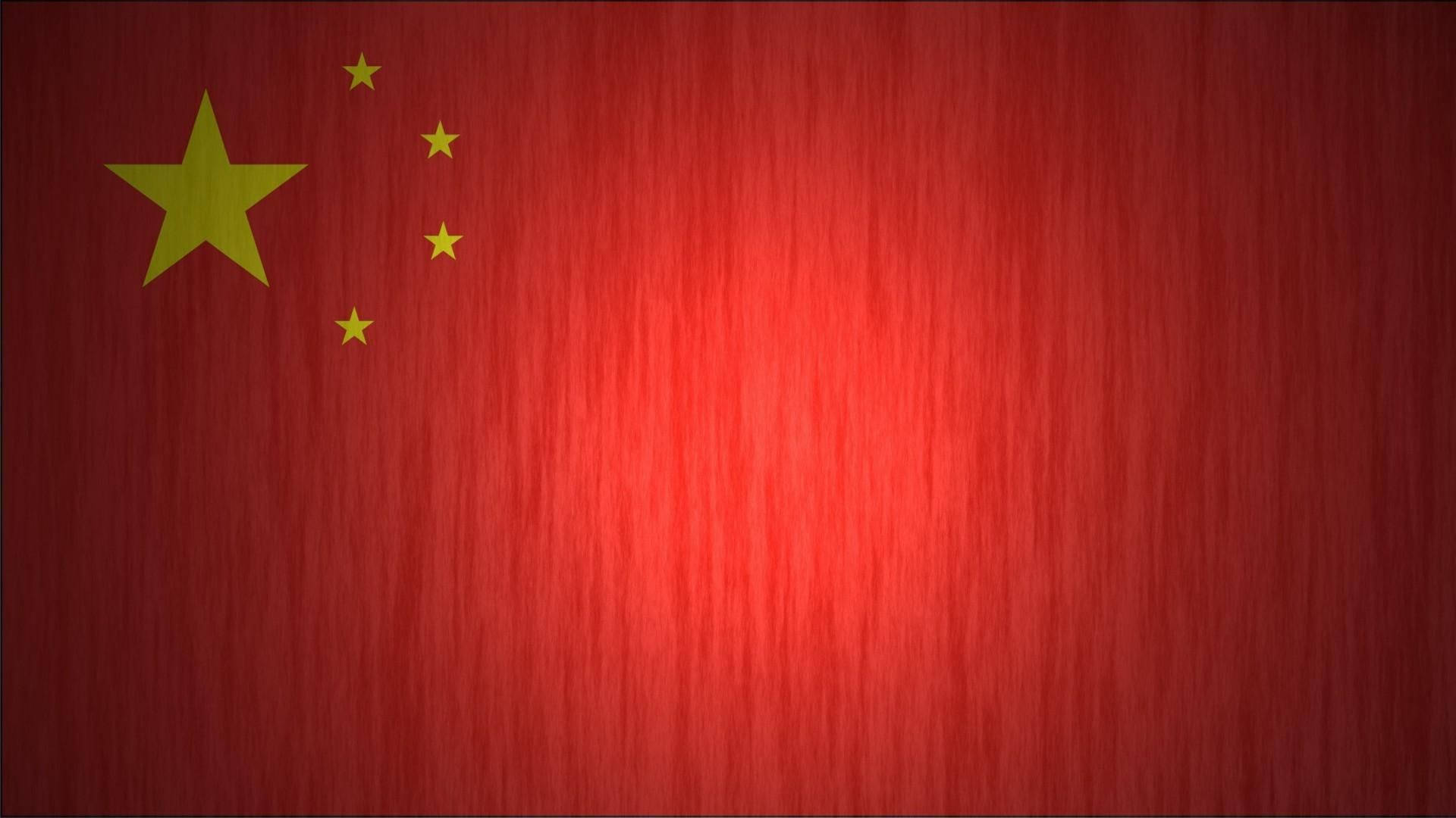 中國國旗光效 壁紙 — 帶有金色星星的中國國旗，背景為有紋理的紅色布料。