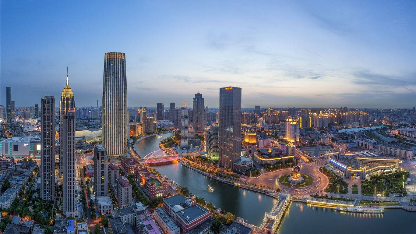黃昏時分的城市天際線，發光的建築物和河流