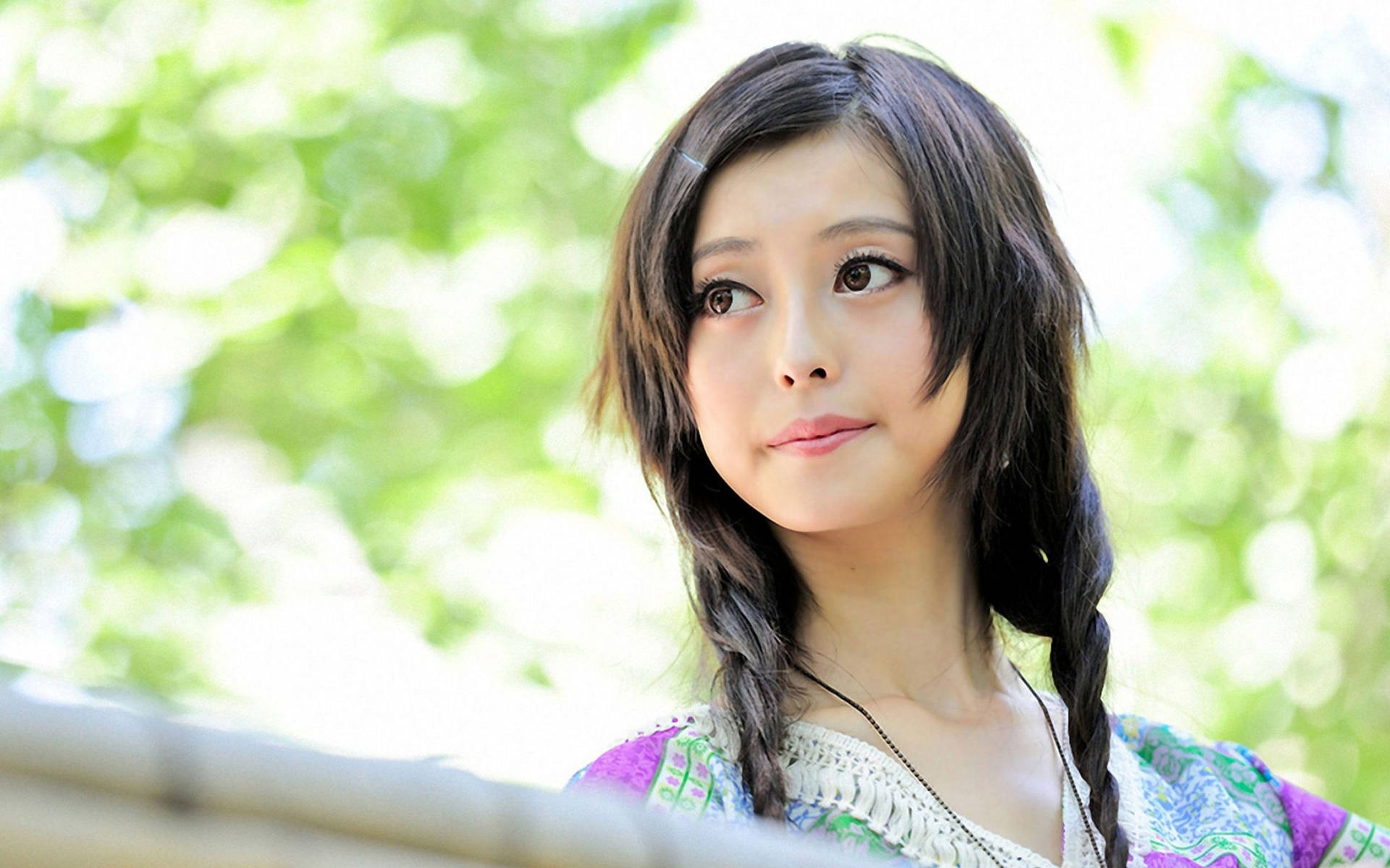年輕女子編著辮子，在陽光明媚的花園中向上看。