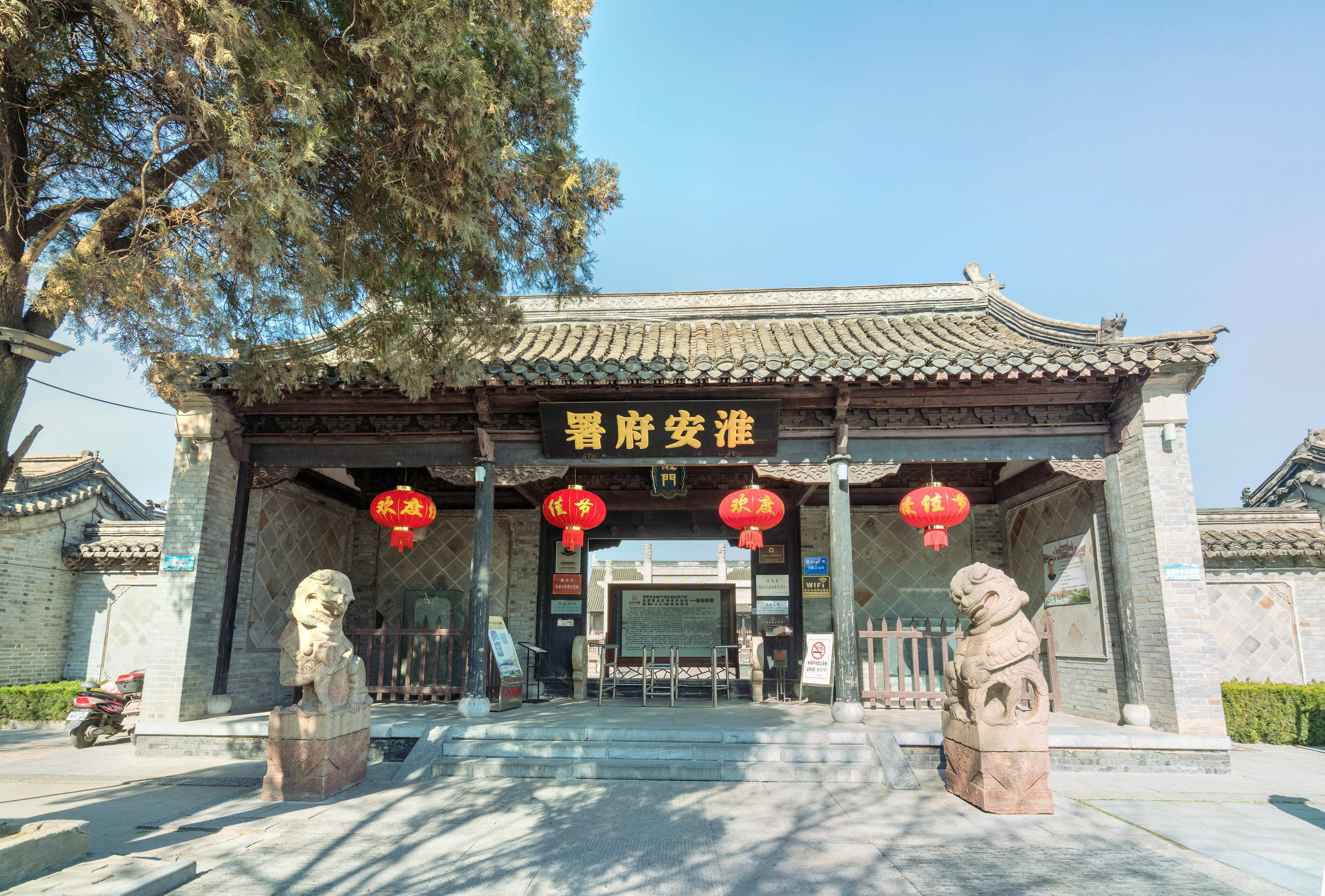 中國淮安城市 壁紙 — 傳統中式門樓，石獅守護，紅燈籠高掛，晴空萬里。