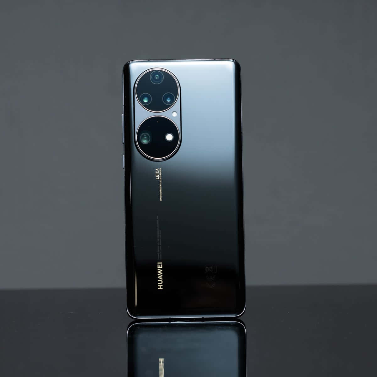 黑色Huawei手機配備Leica相機模組，置於反光表面。