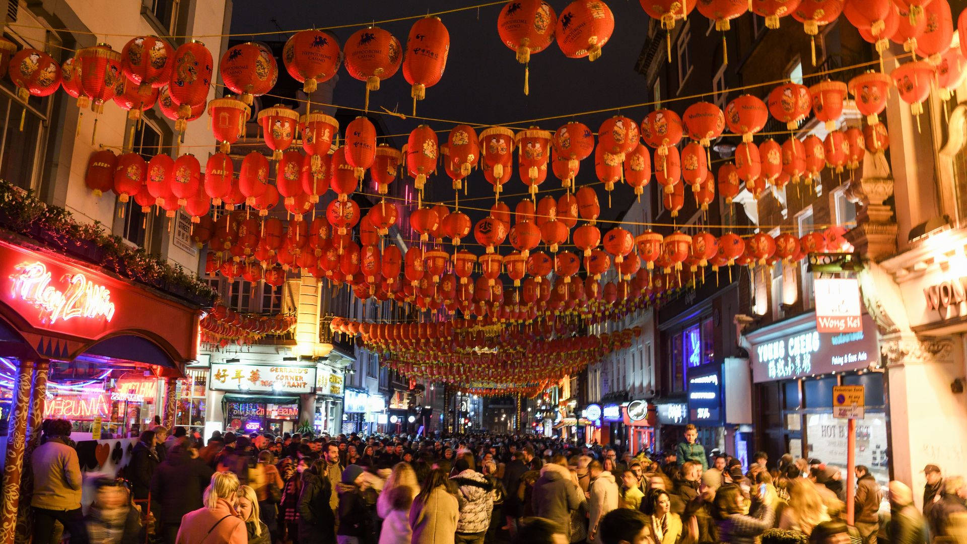 夜晚擁擠的街道，掛滿紅色燈籠慶祝中國節日。