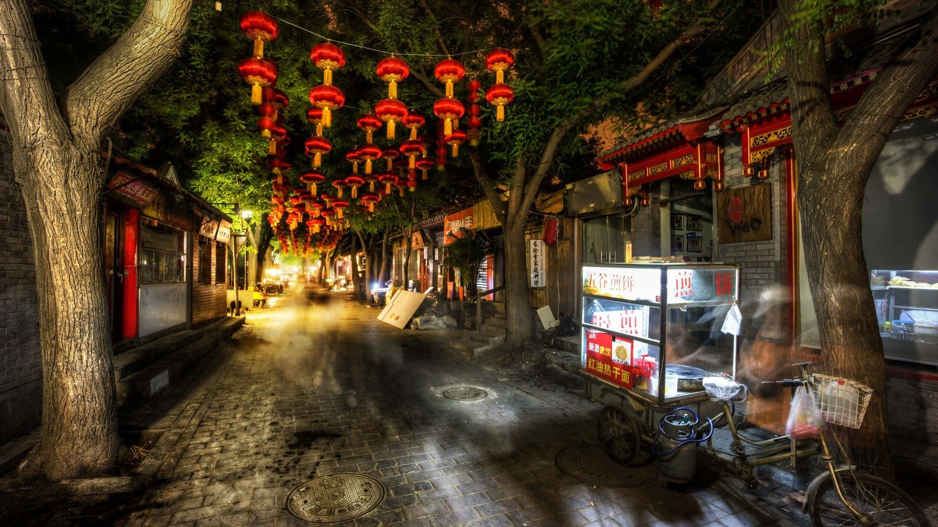 夜晚街道，有紅燈籠和樹下的美食車