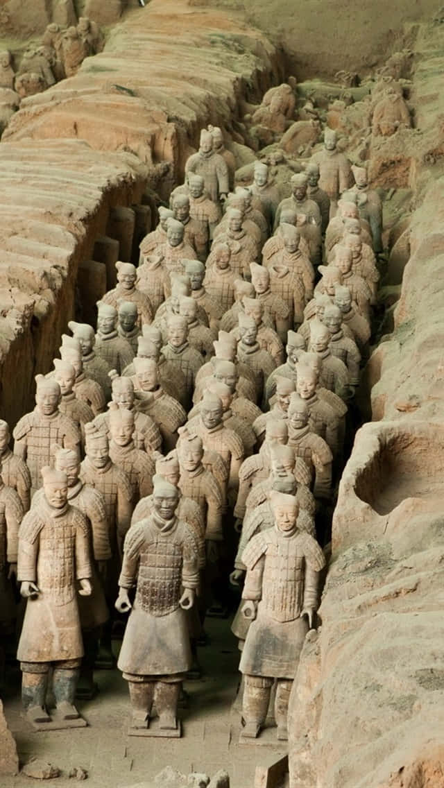 中國陶俑雕塑酷炫造型 壁紙 — 一排排古代兵馬俑在其發掘坑內列隊站立，大地色調主導場景。